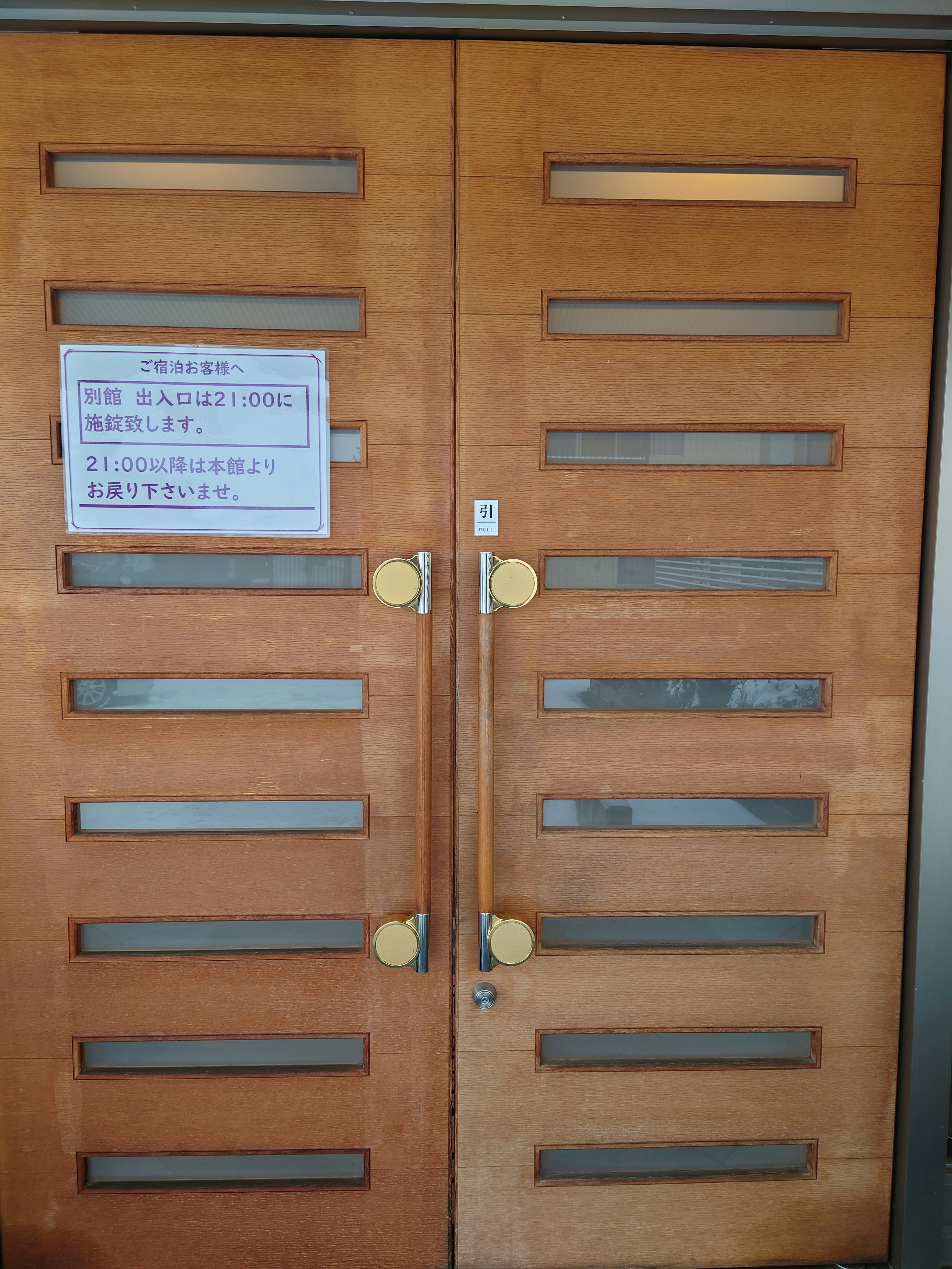 Wooden door with horizontal windows and a notice attached