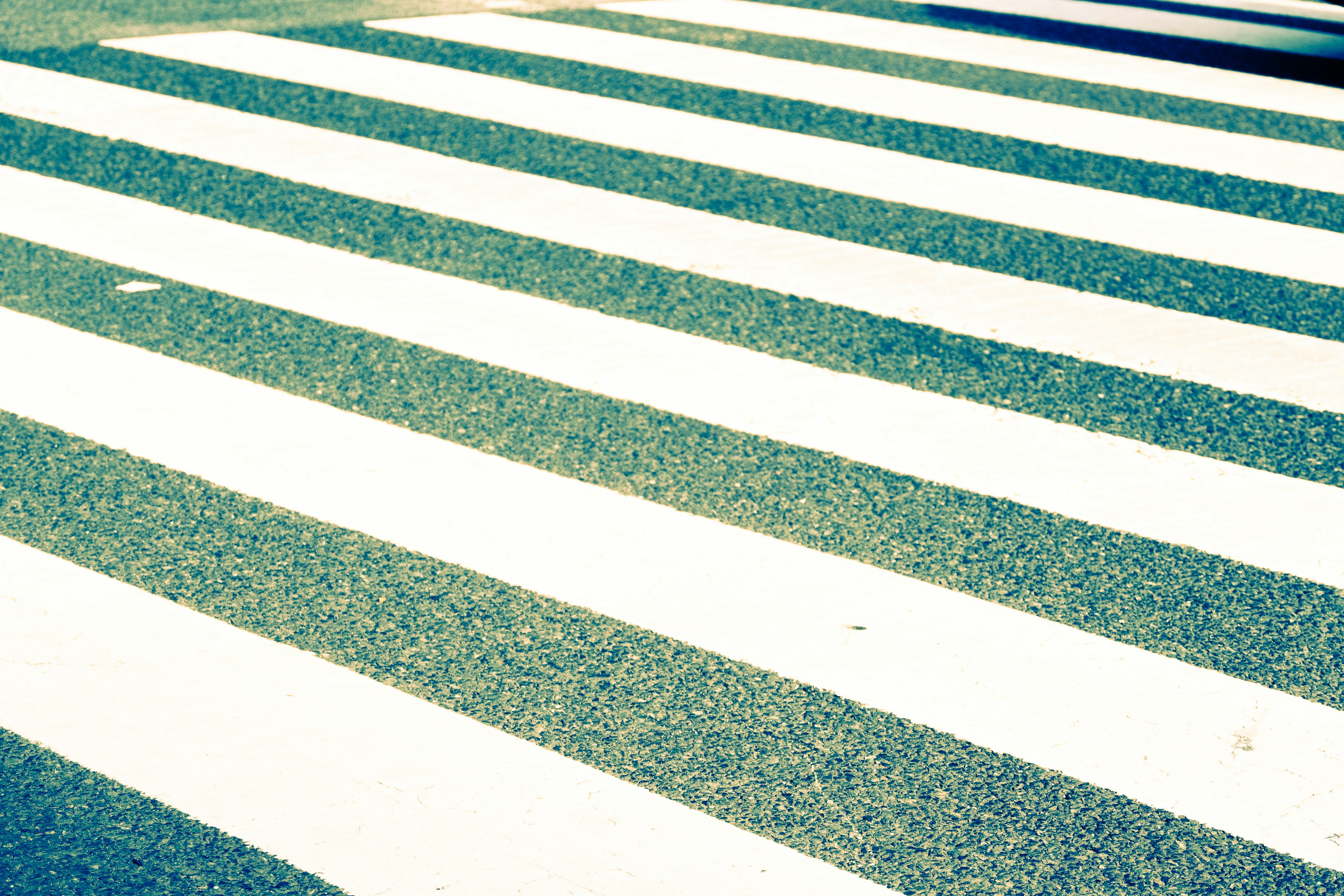 White crosswalk stripes on a blue surface