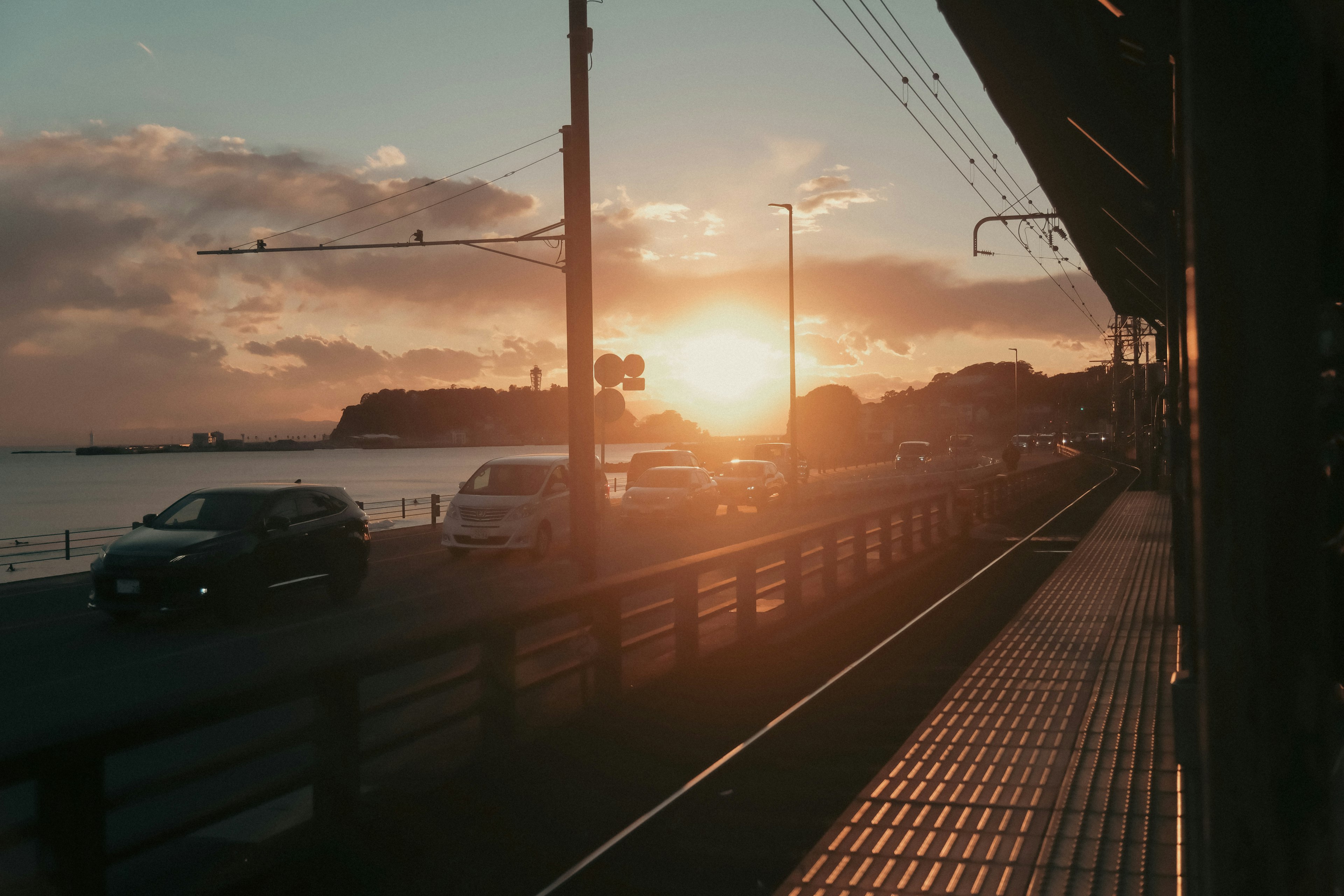 海上日落的风景，有汽车和建筑物