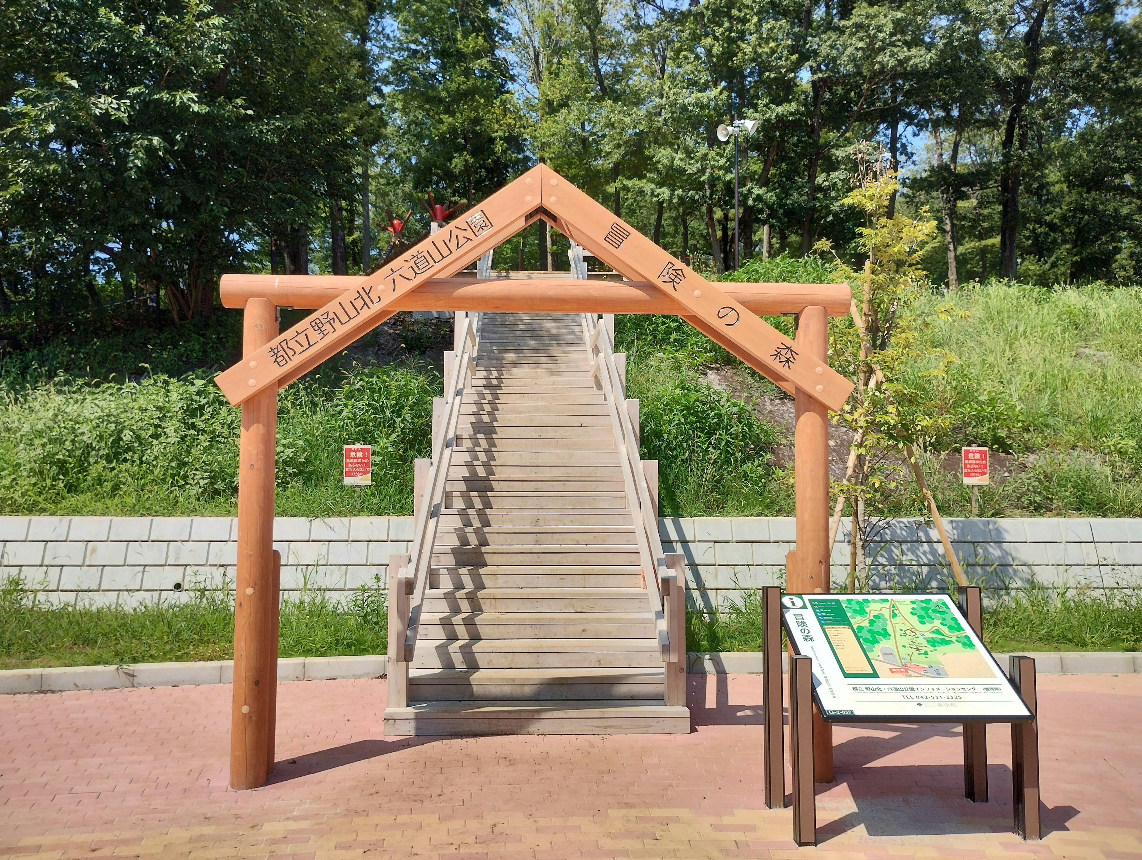 Entrada de un parque con un arco de madera y escaleras