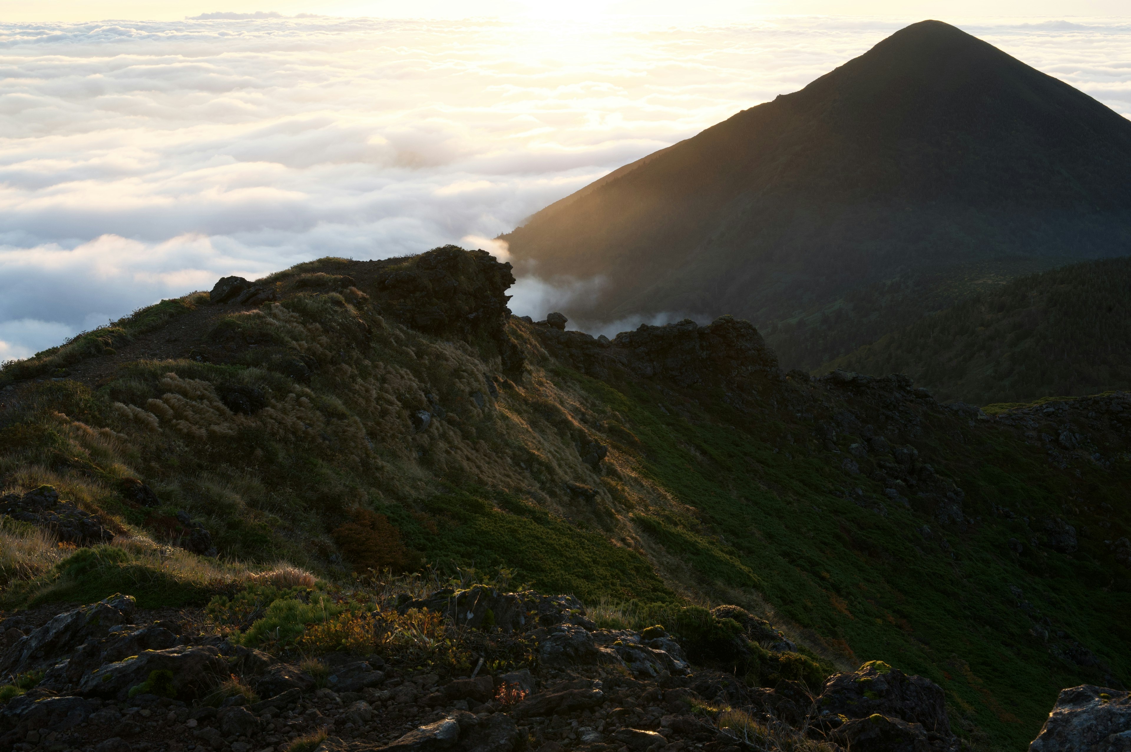 Paysage montagneux avec un coucher de soleil et une mer de nuages