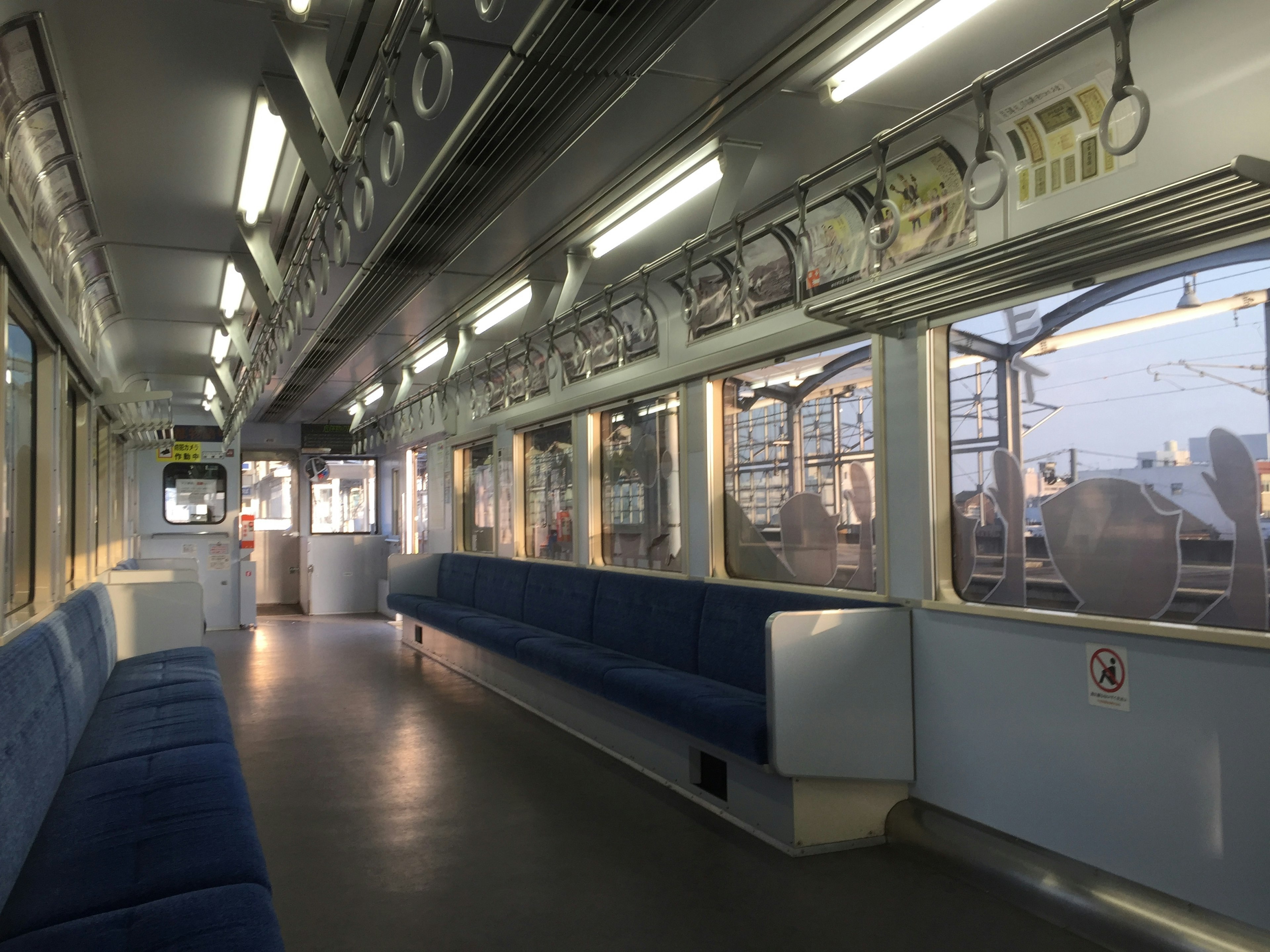 Interior of a quiet train carriage with blue seating