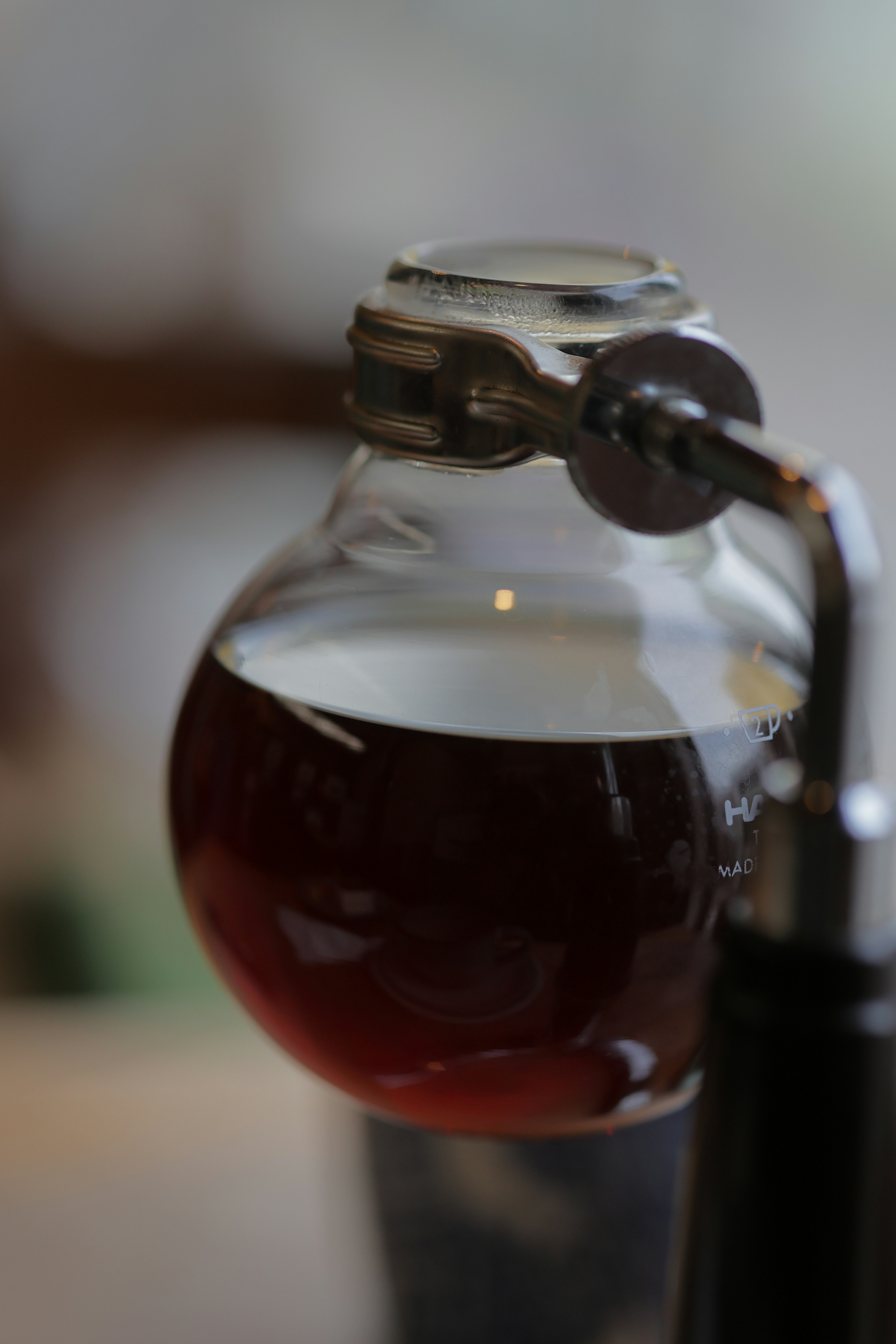 Glass bottle containing dark liquid with metal cap