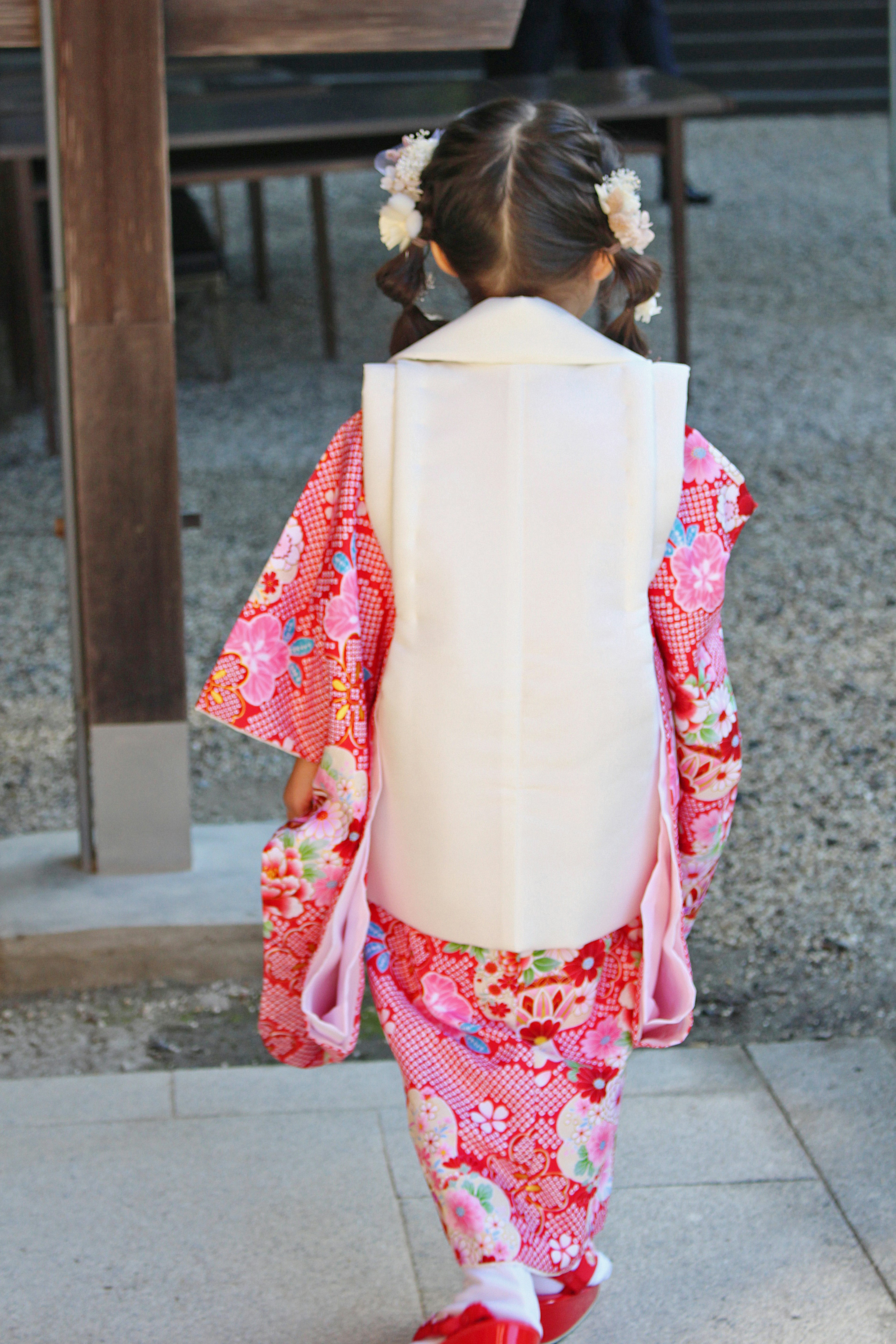 Seorang gadis kecil mengenakan kimono pink menghadap ke belakang