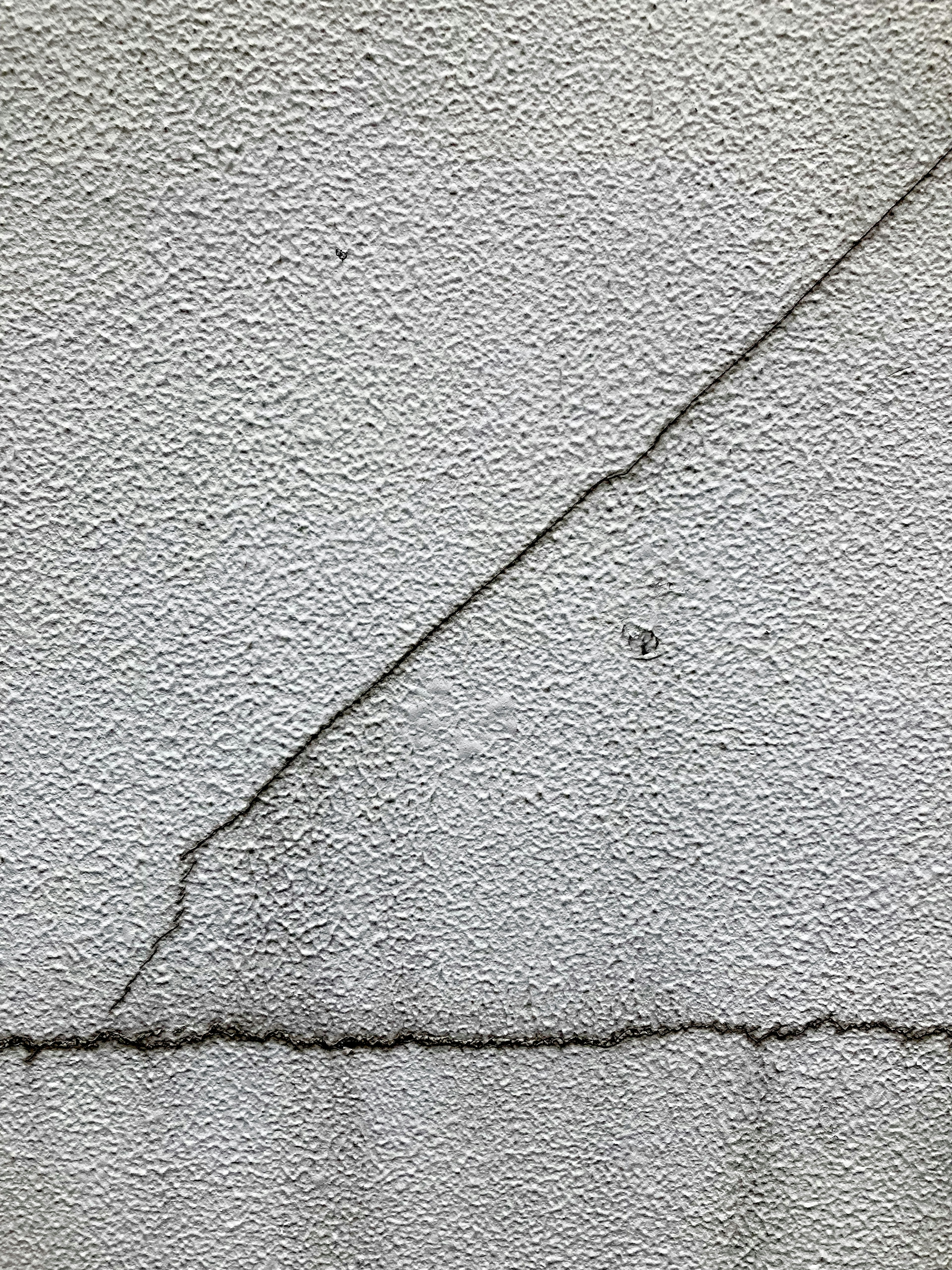 Mur gris texturé avec des fissures et des motifs