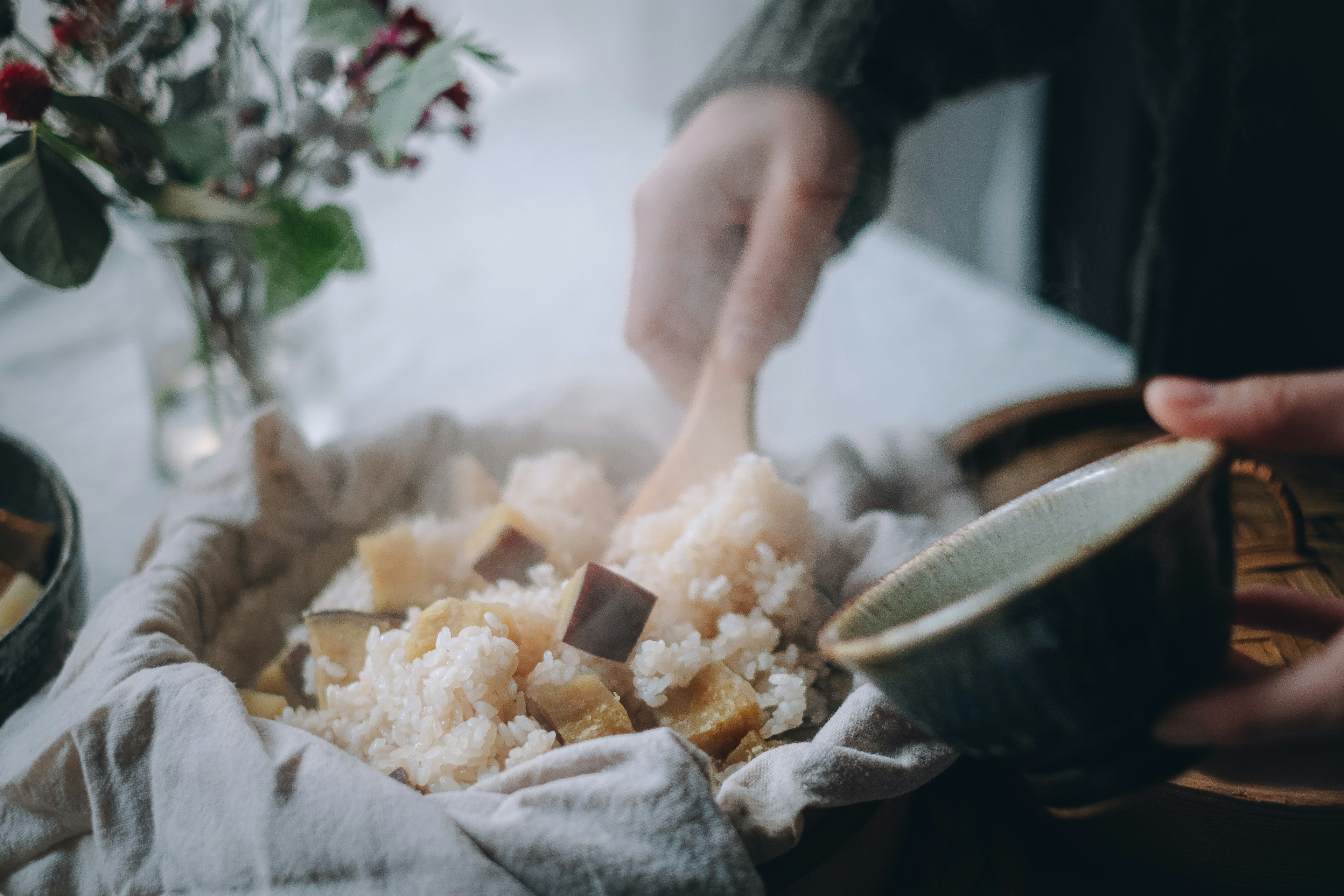 Scene of a hand serving warm rice with a bowl