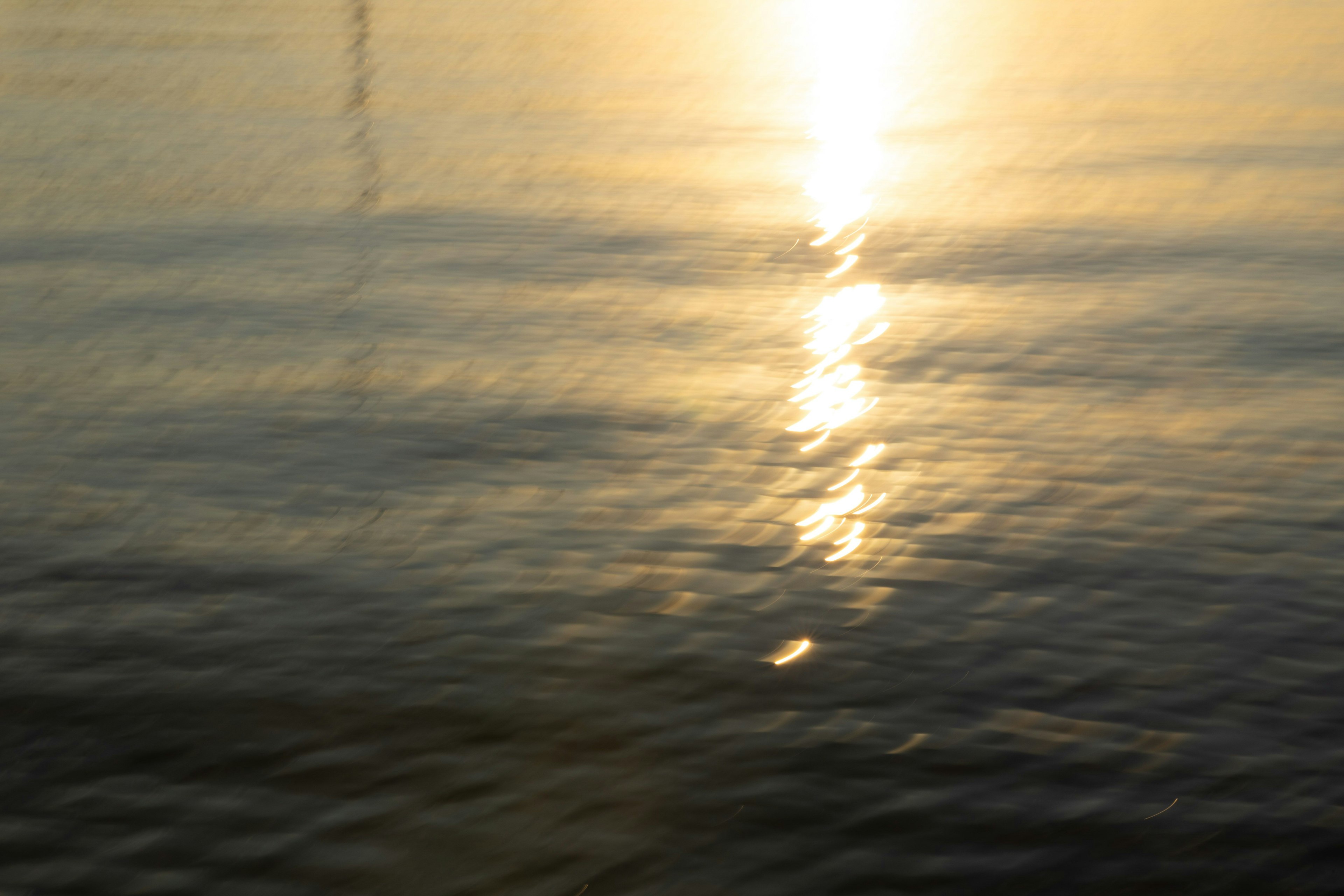 水面に反射する夕日の光が美しい静かな風景