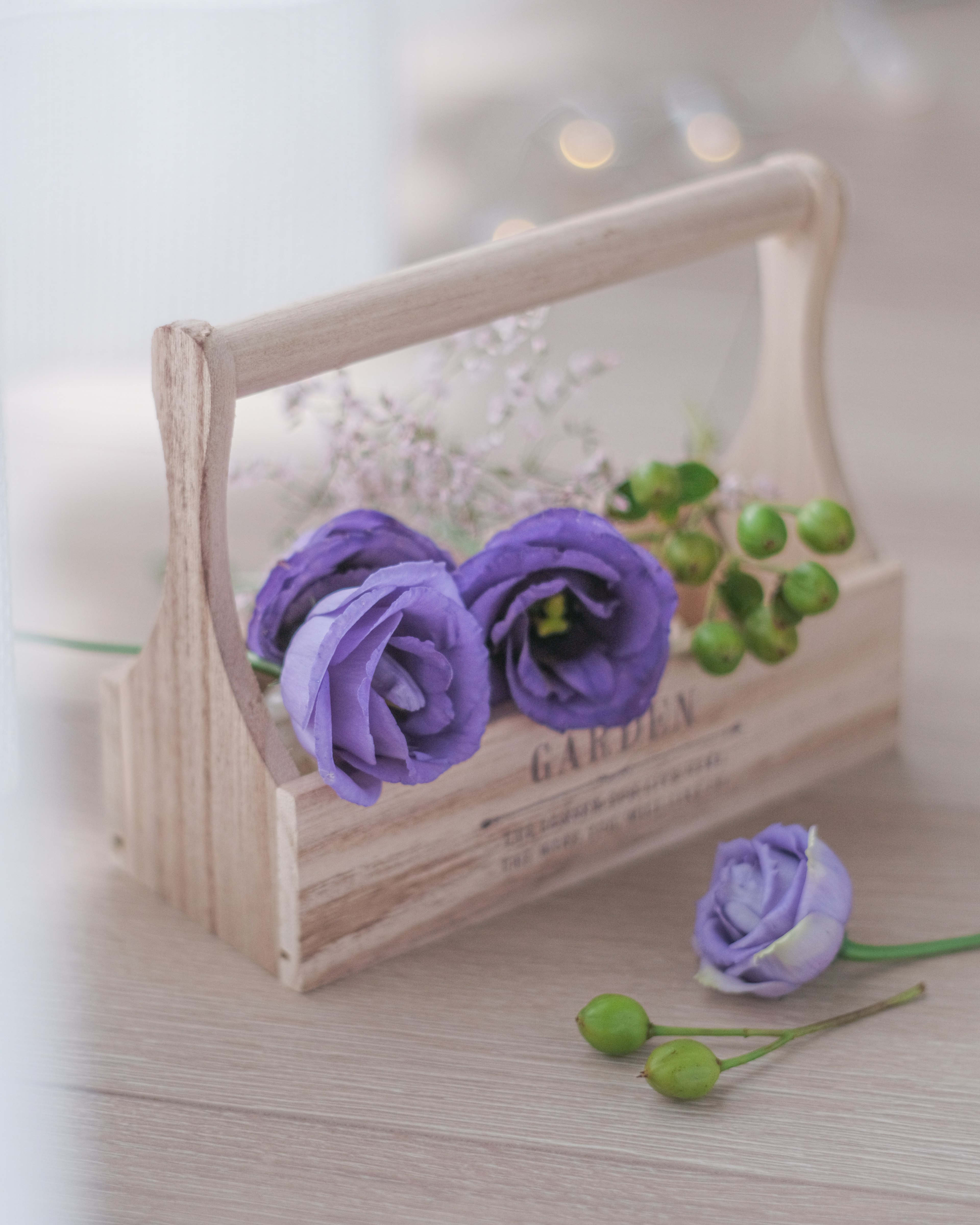 Scatola di fiori in legno con fiori viola e boccioli verdi