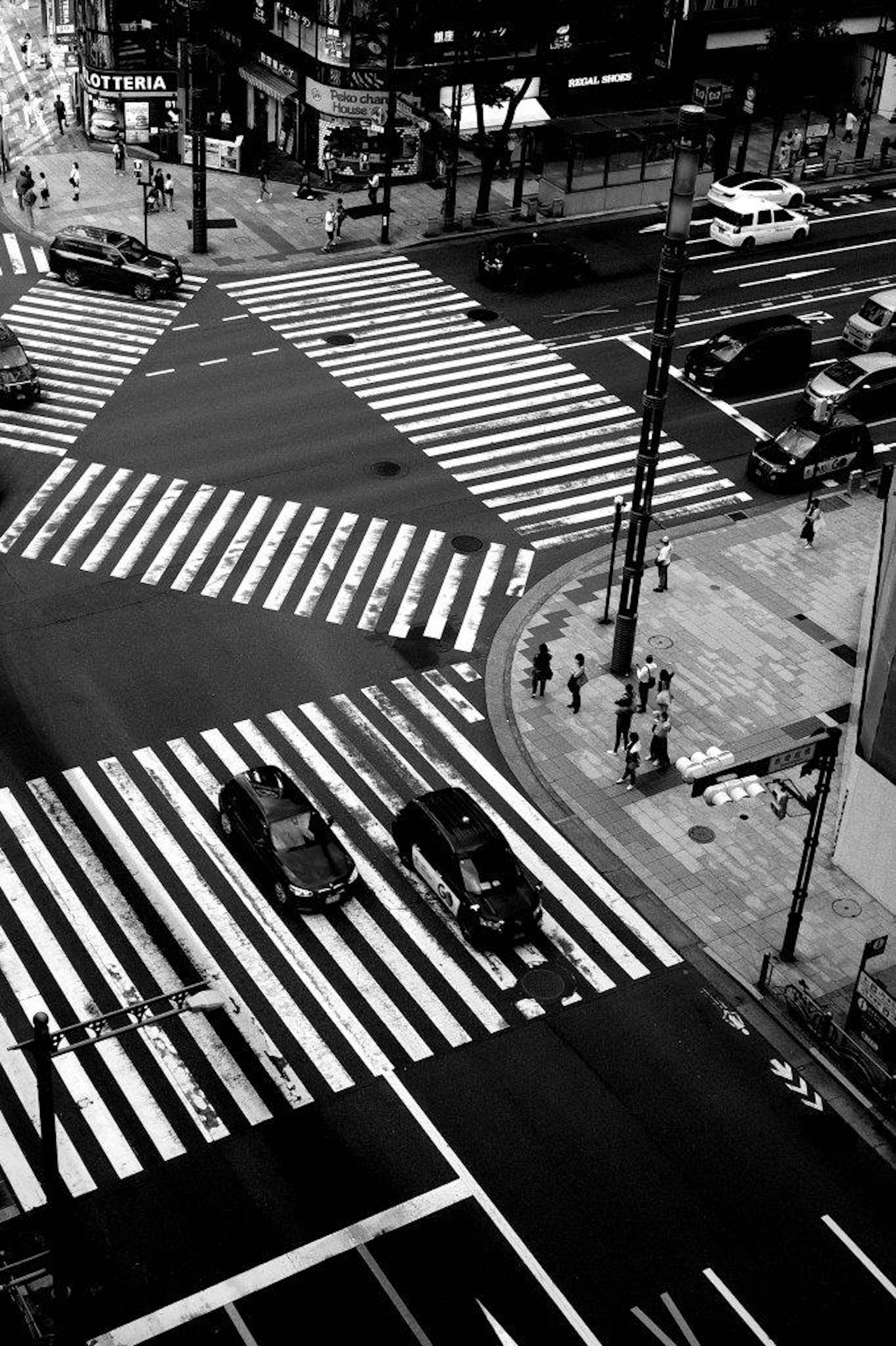 Intersección con pasos de peatones en blanco y negro y vehículos