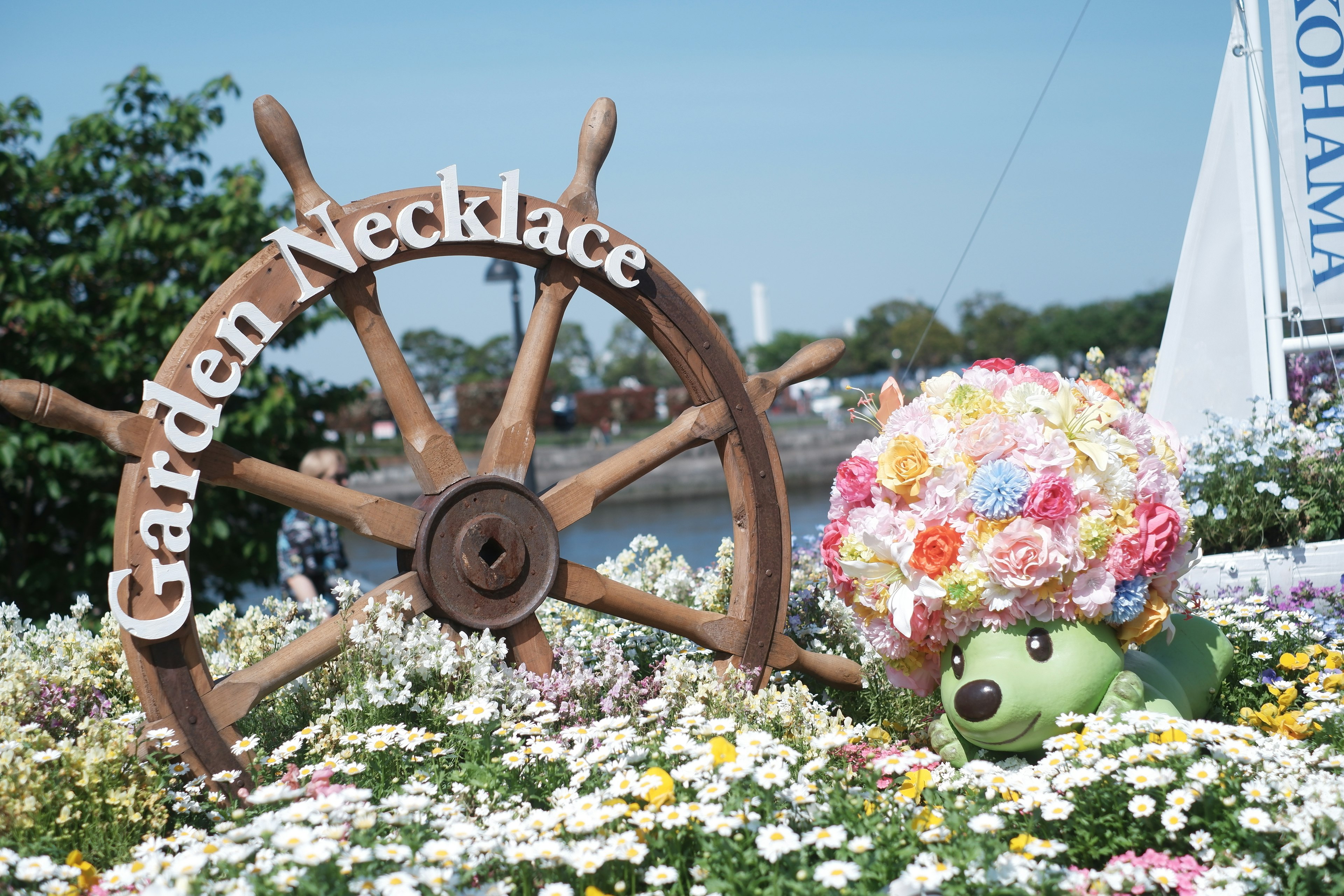 Photo of a sign reading Garden Necklace with a flower-adorned character