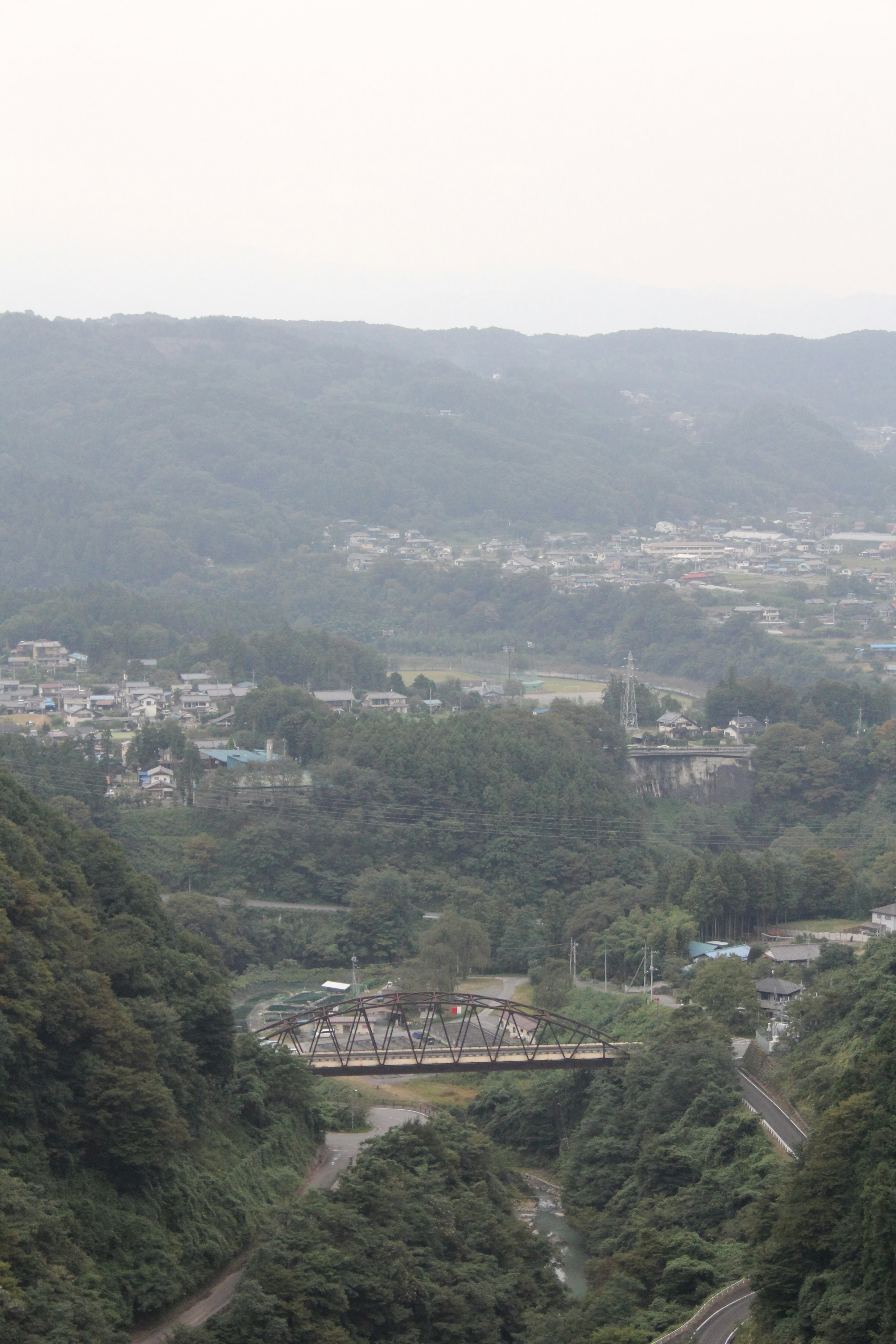 Vue panoramique d'une vallée avec un pont entouré de collines