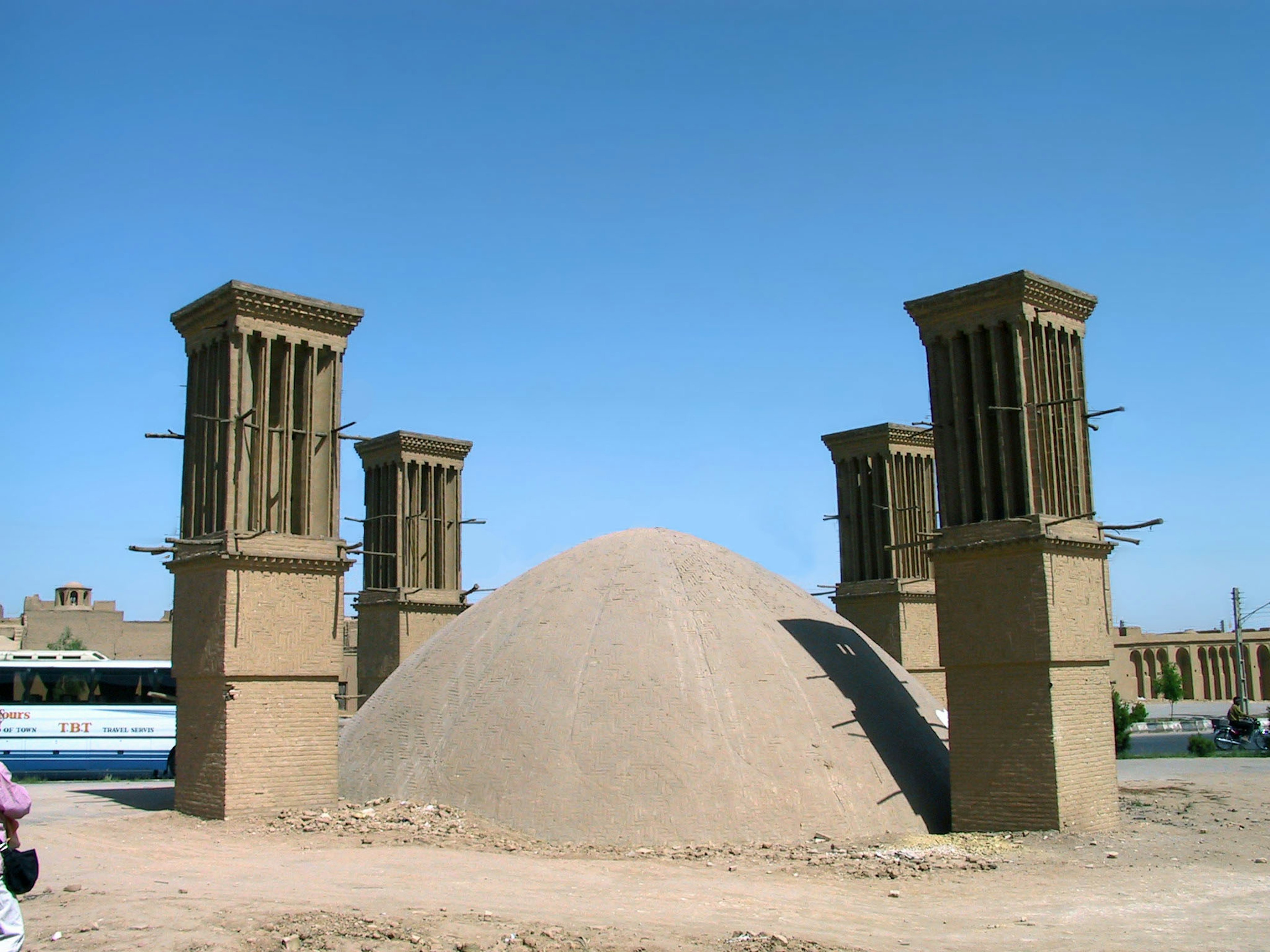 A sand mound surrounded by four windcatchers in a dry landscape