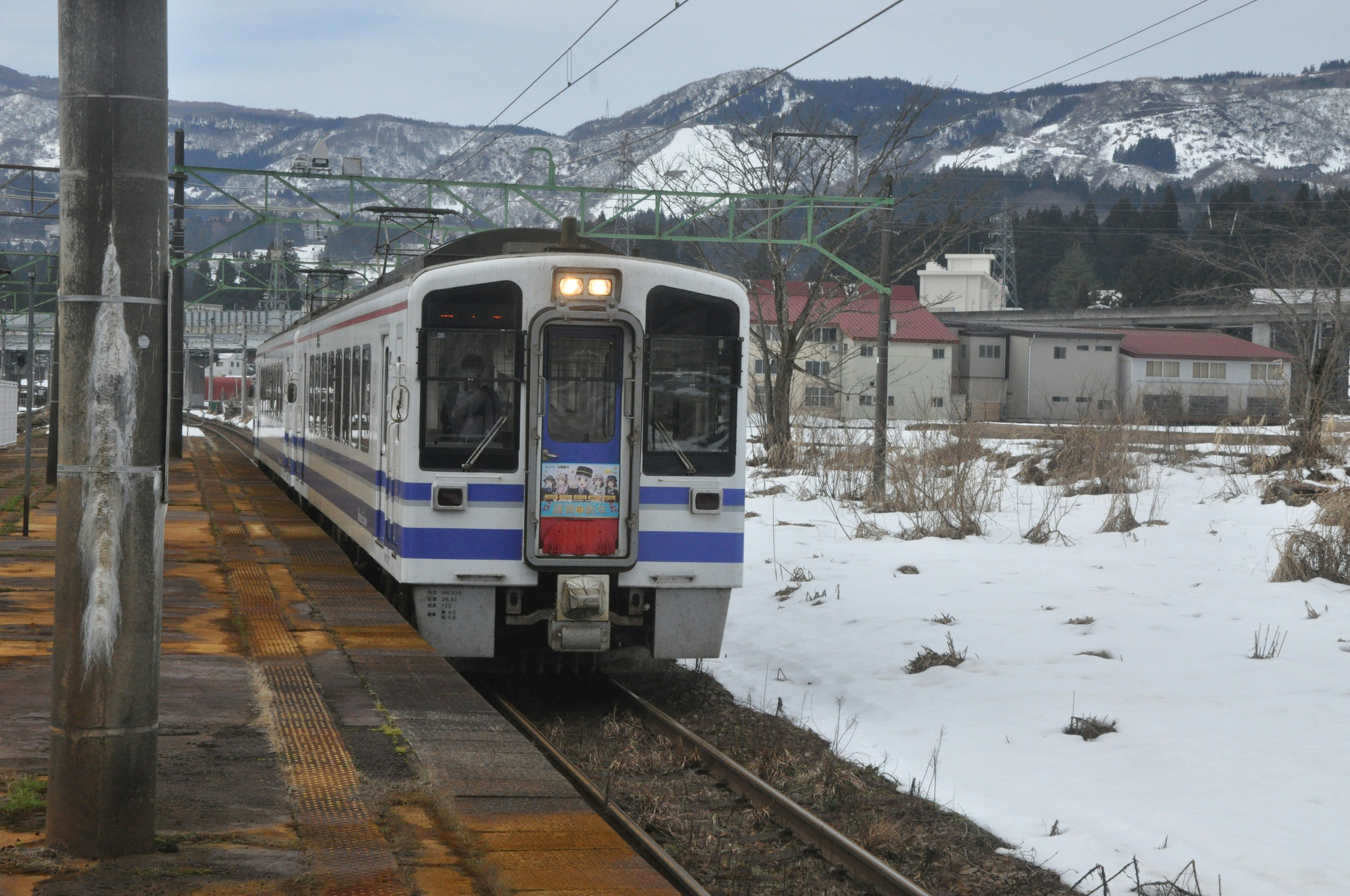 Treno che corre nella neve con montagne sullo sfondo