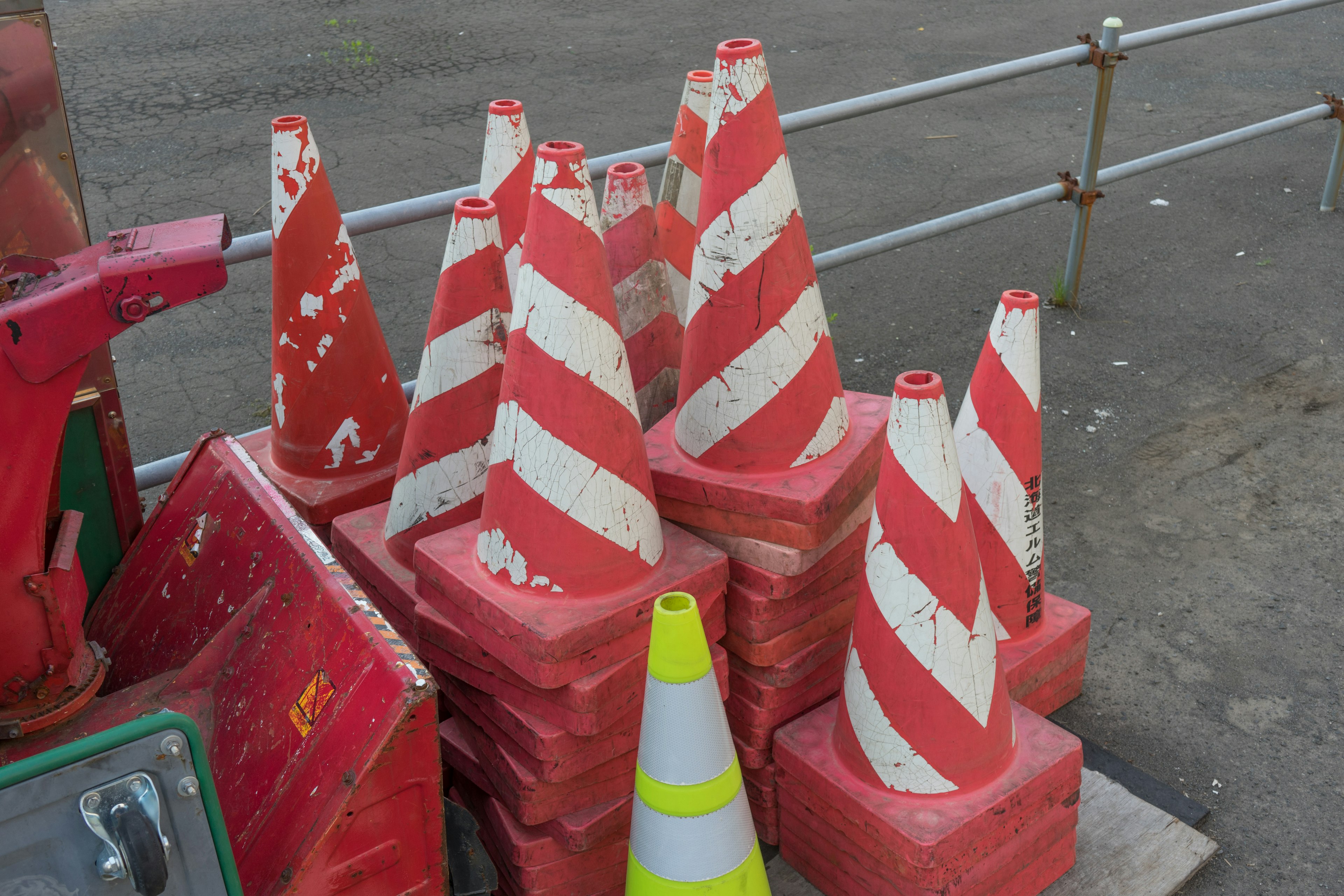 Stack of red and white striped traffic cones at a construction site