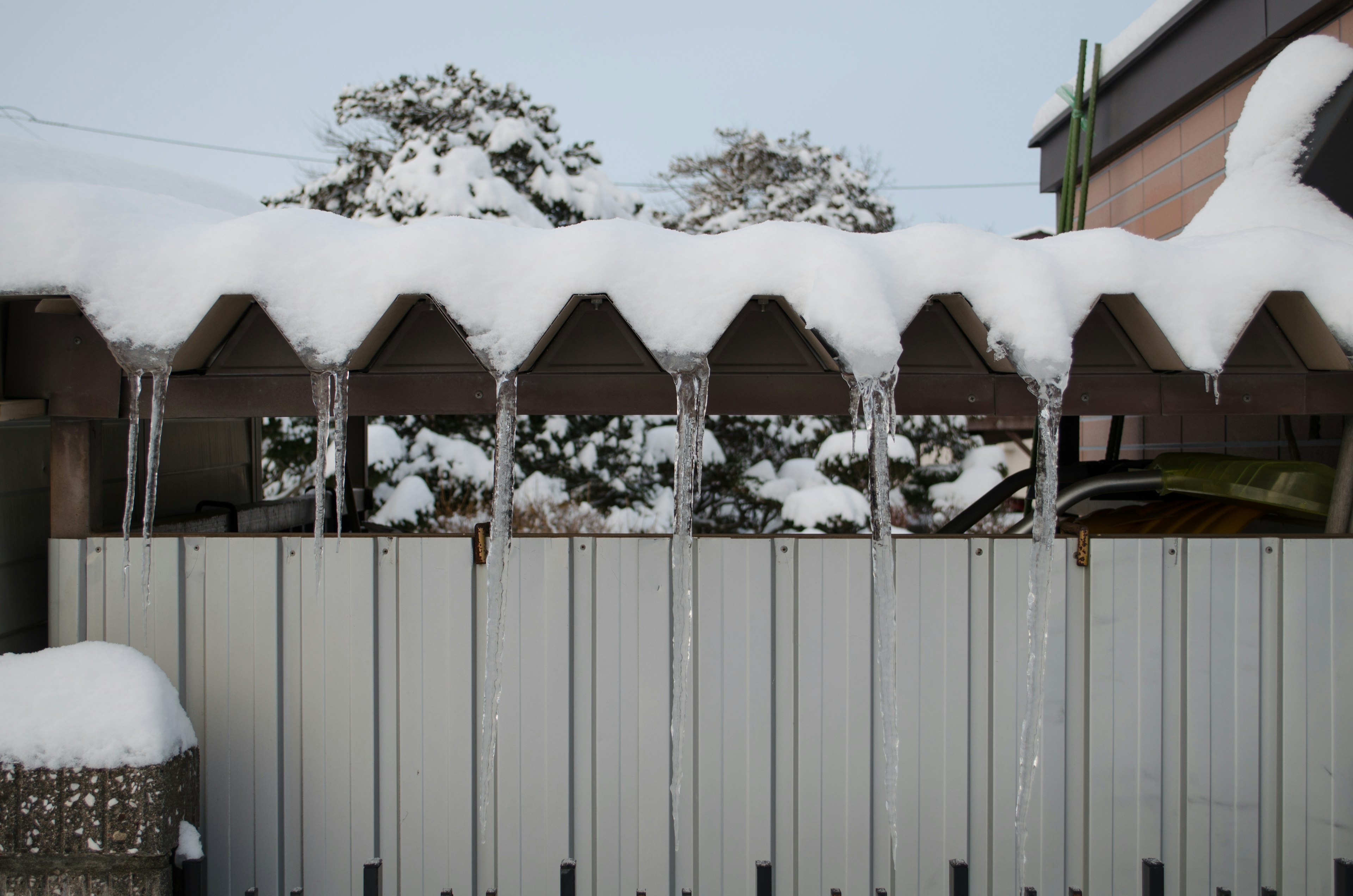 Snow-covered roof with icicles hanging down