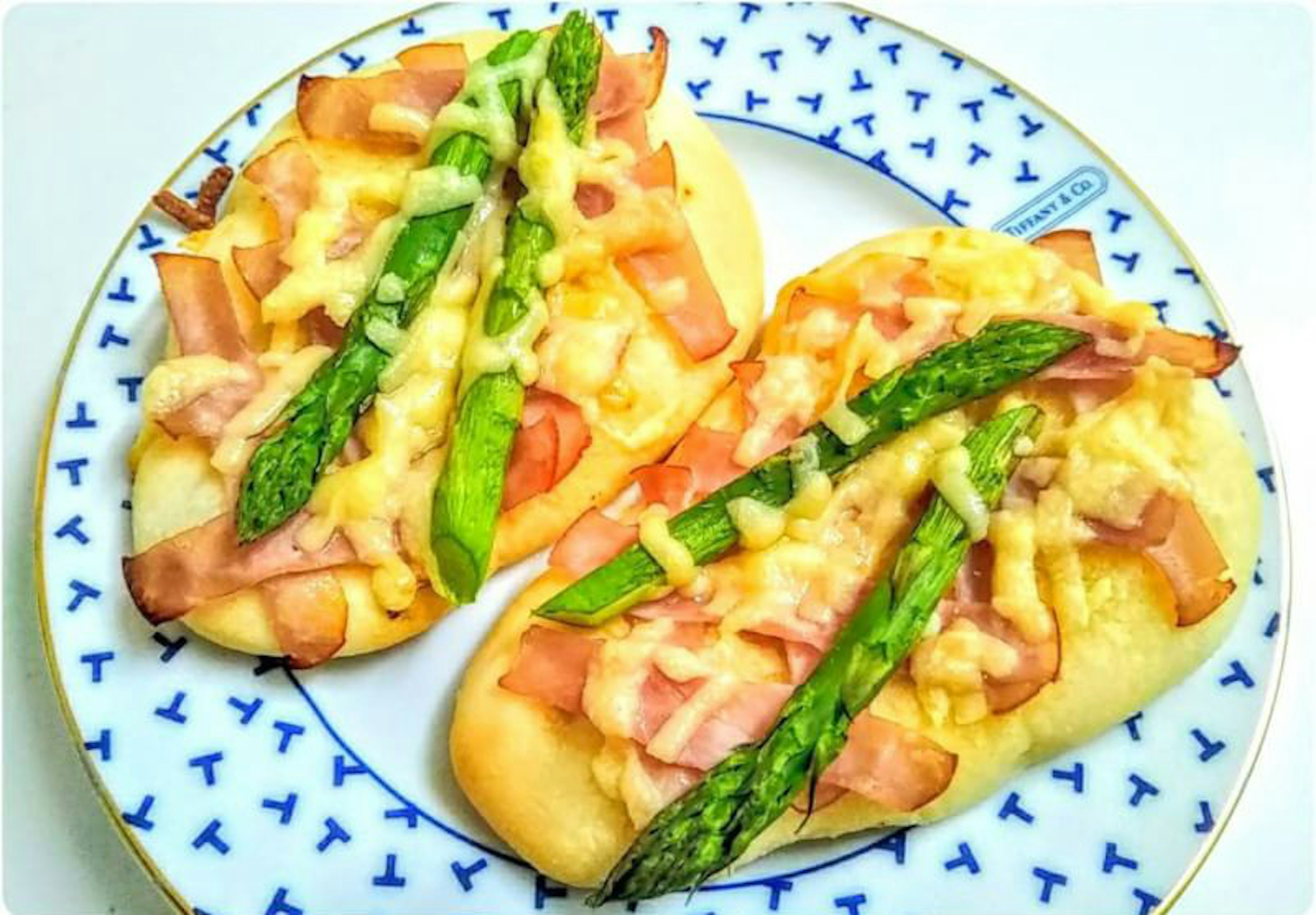 Roti bakar dengan asparagus dan ham di piring dekoratif