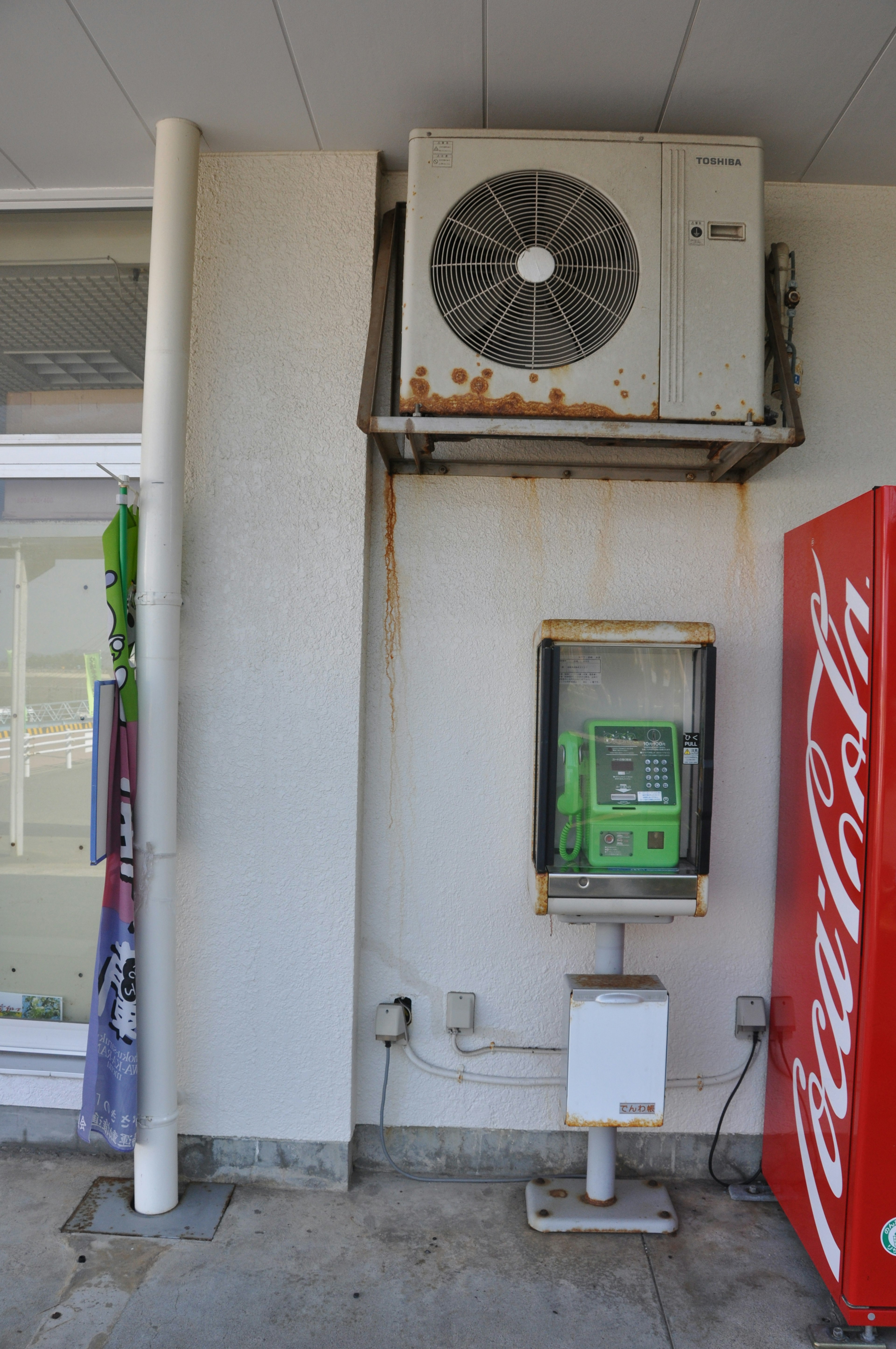 Wall featuring an air conditioning unit and a public phone booth