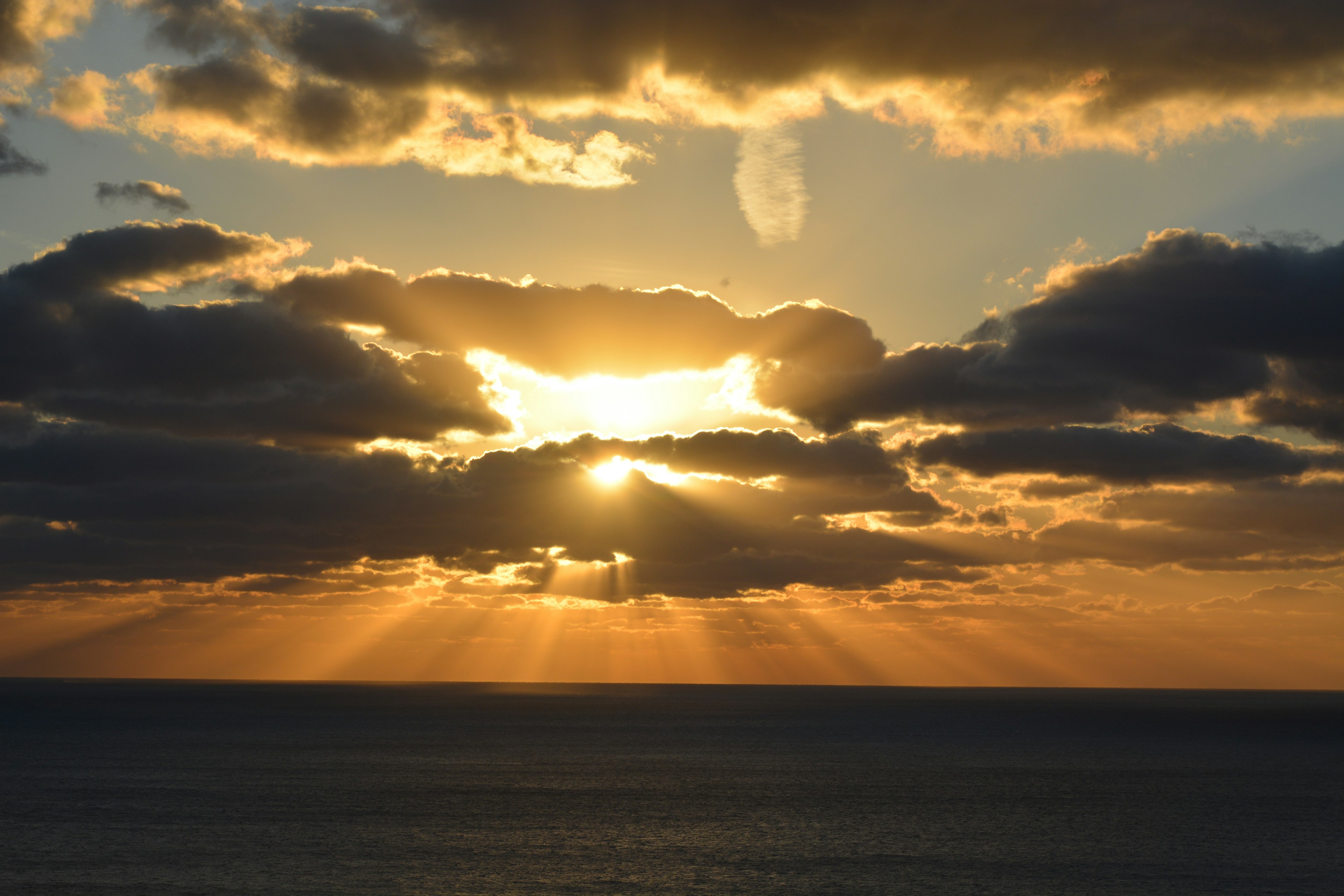 夕日が雲の間から差し込む美しい海の風景