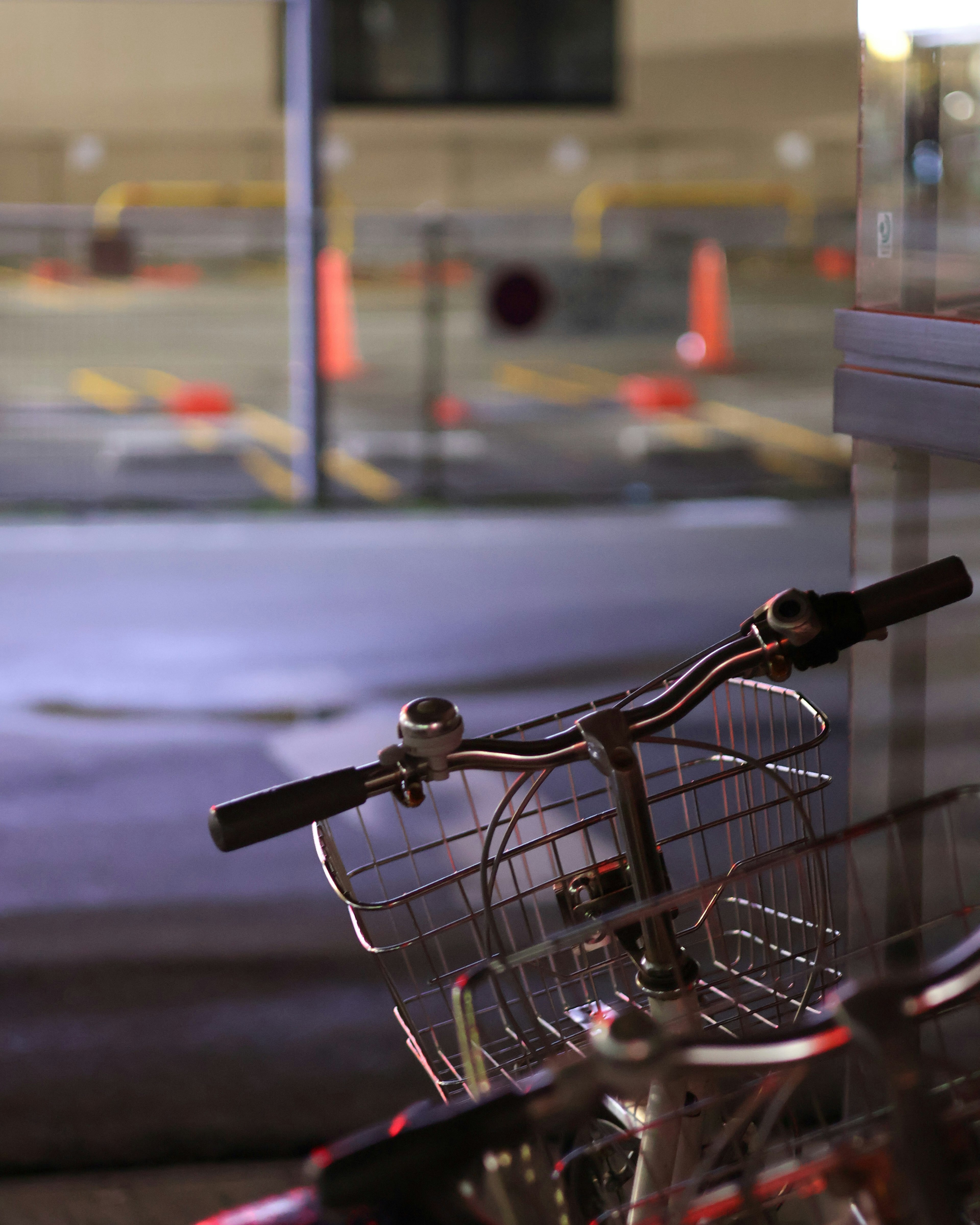 Bicycle handlebars in a dimly lit urban setting at night