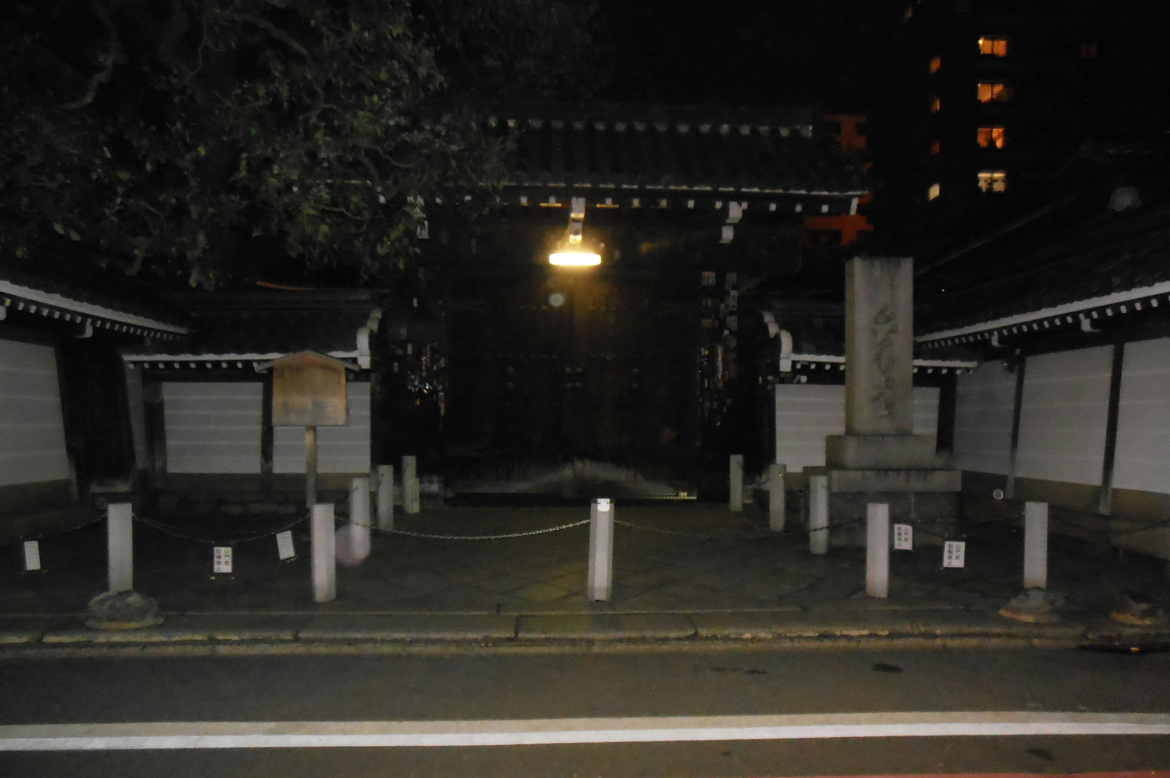 Ingresso di un tempio di notte con un cancello illuminato