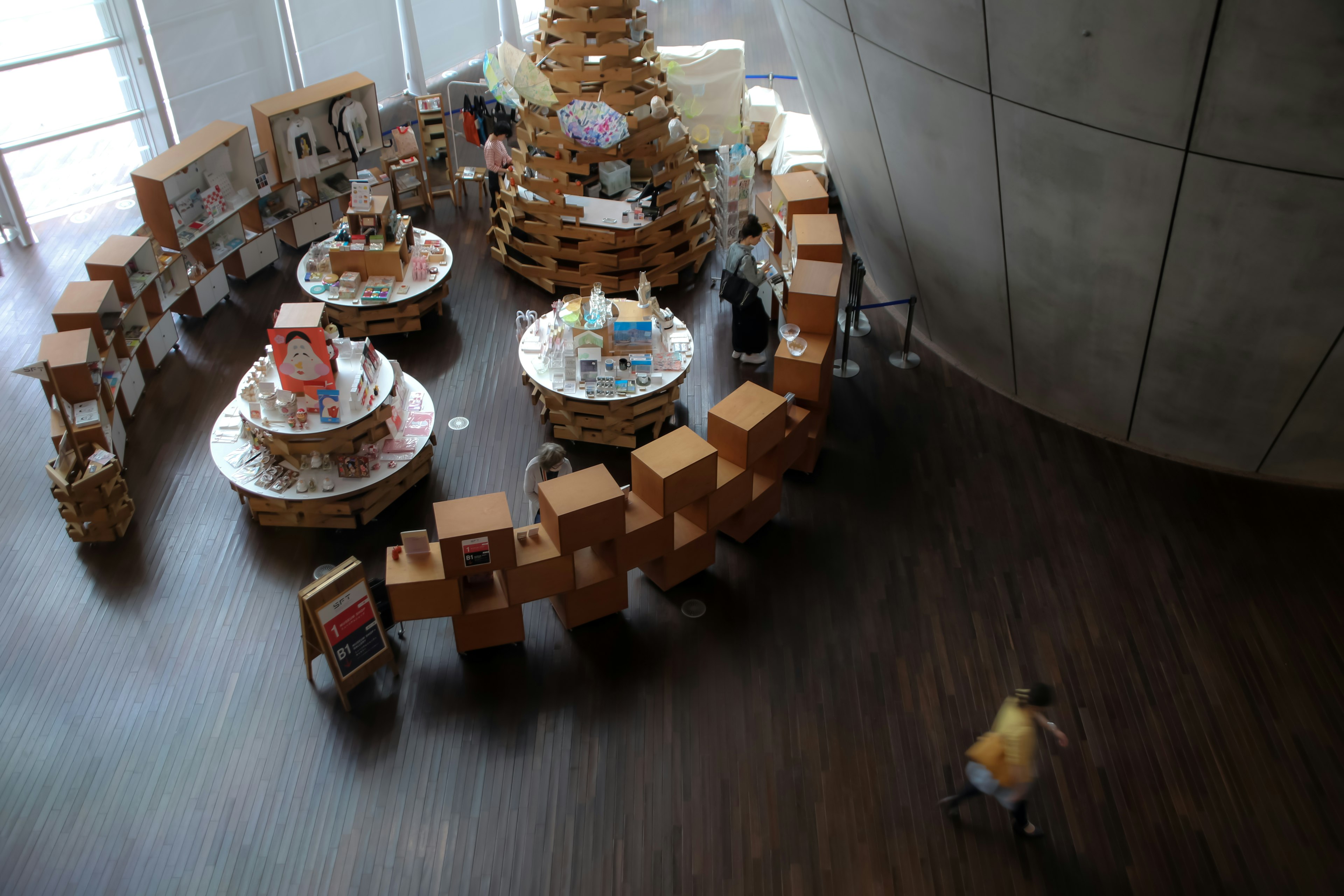 Circular display area with wooden boxes and tables featuring stacked books and materials in the center