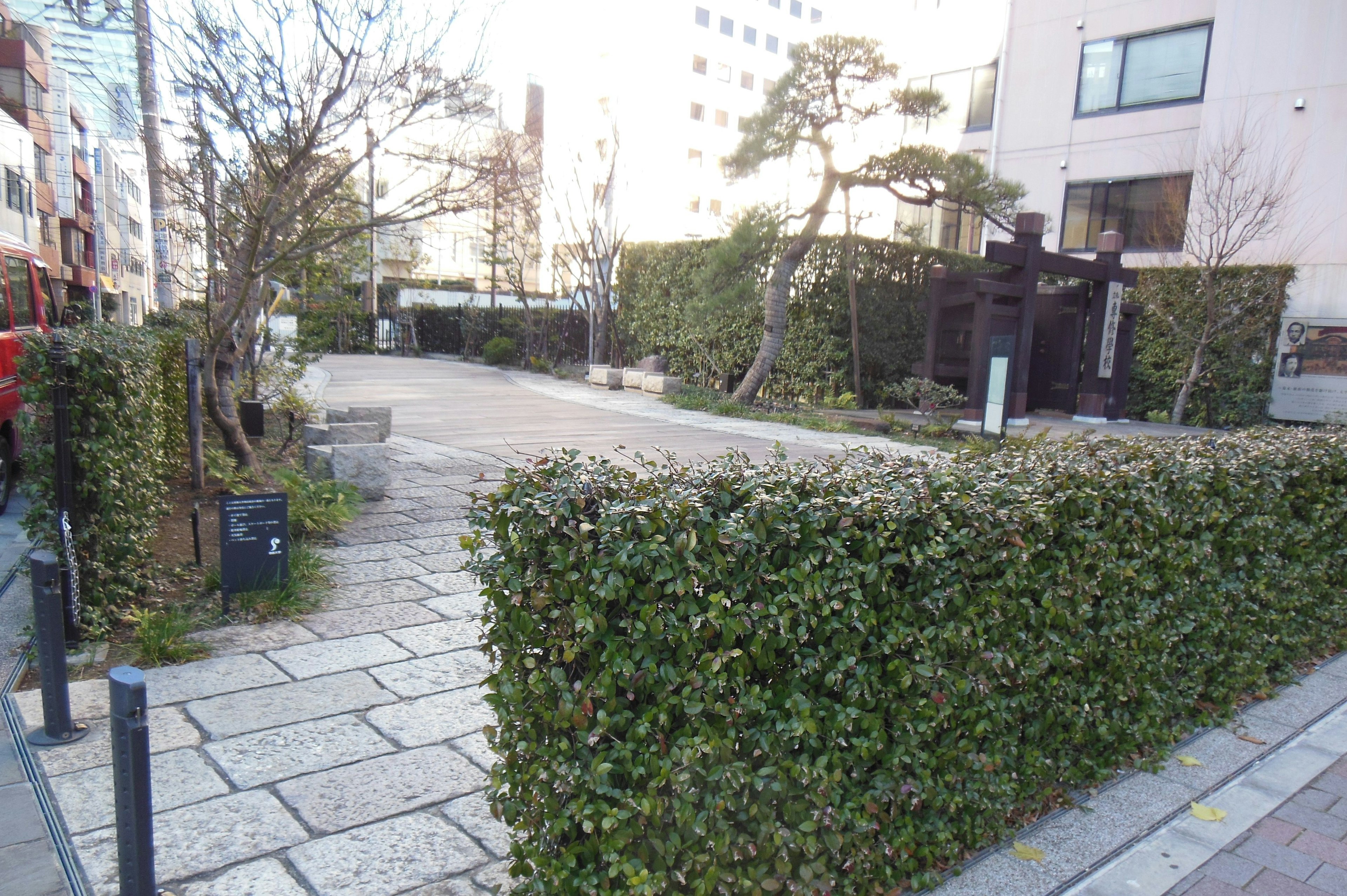 A serene park scene featuring green hedges and stone pathways