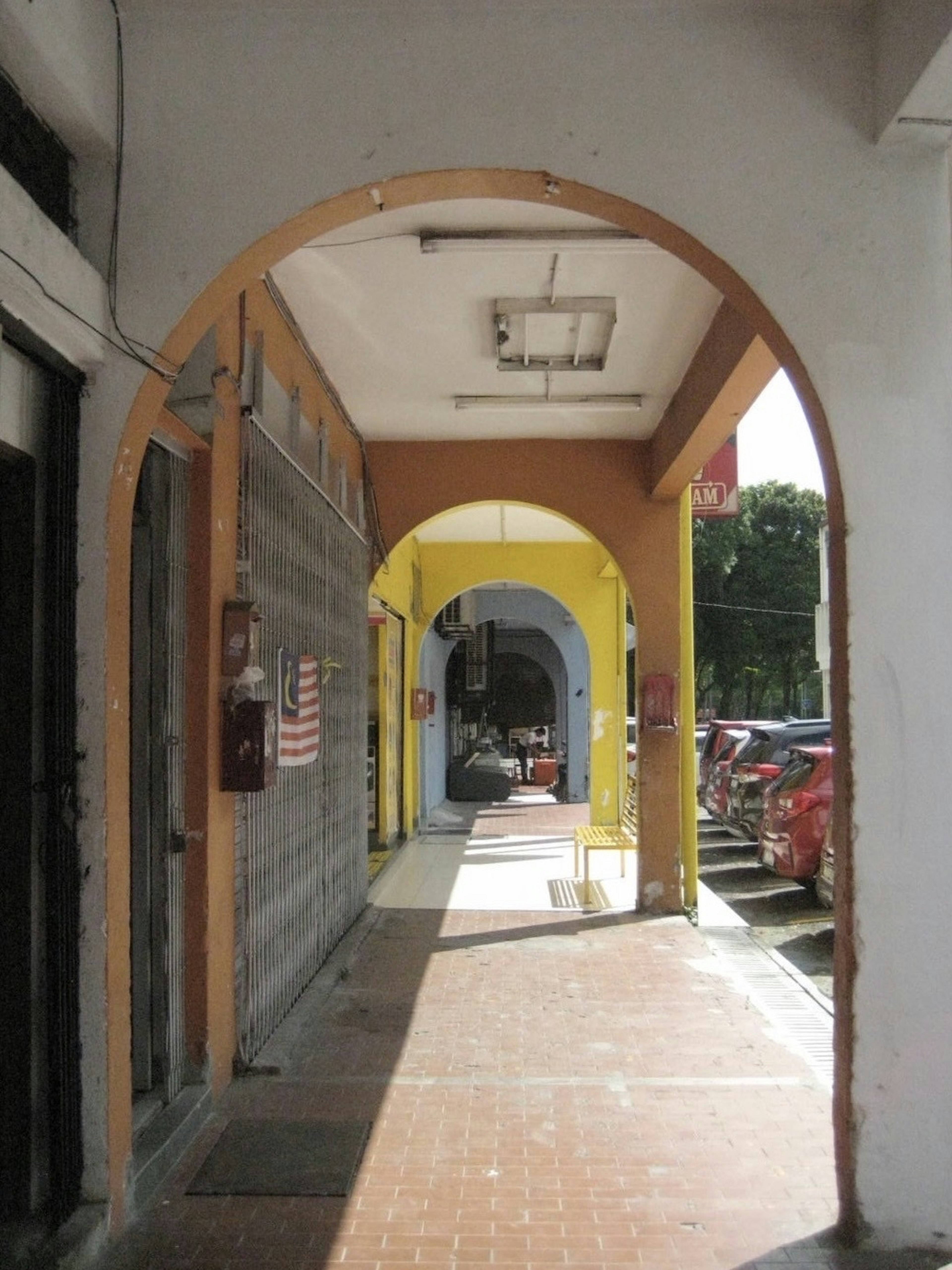 Pasillo con arcos y paredes coloridas en una zona comercial