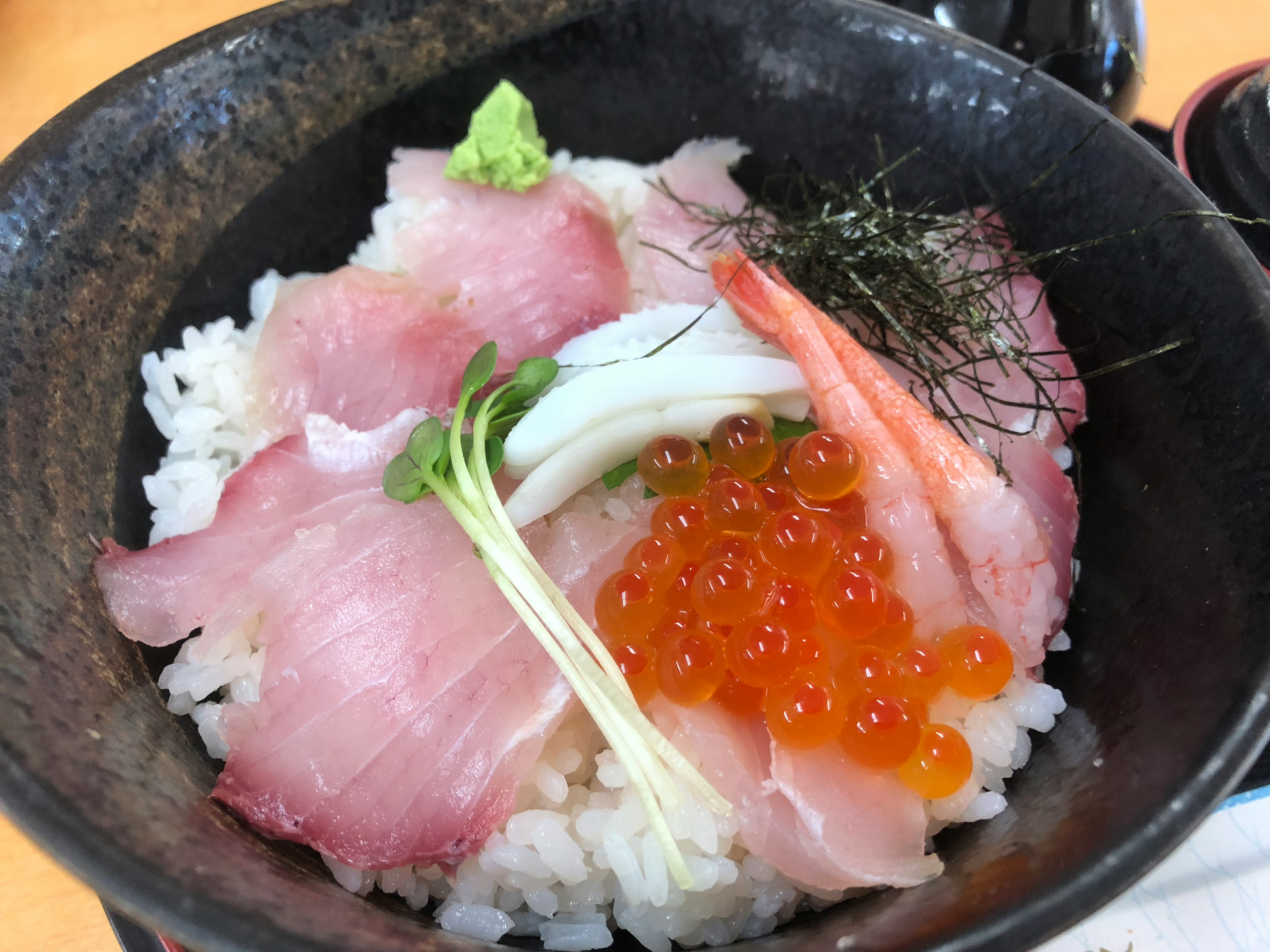 新鮮な刺身とイクラが盛り付けられた丼飯