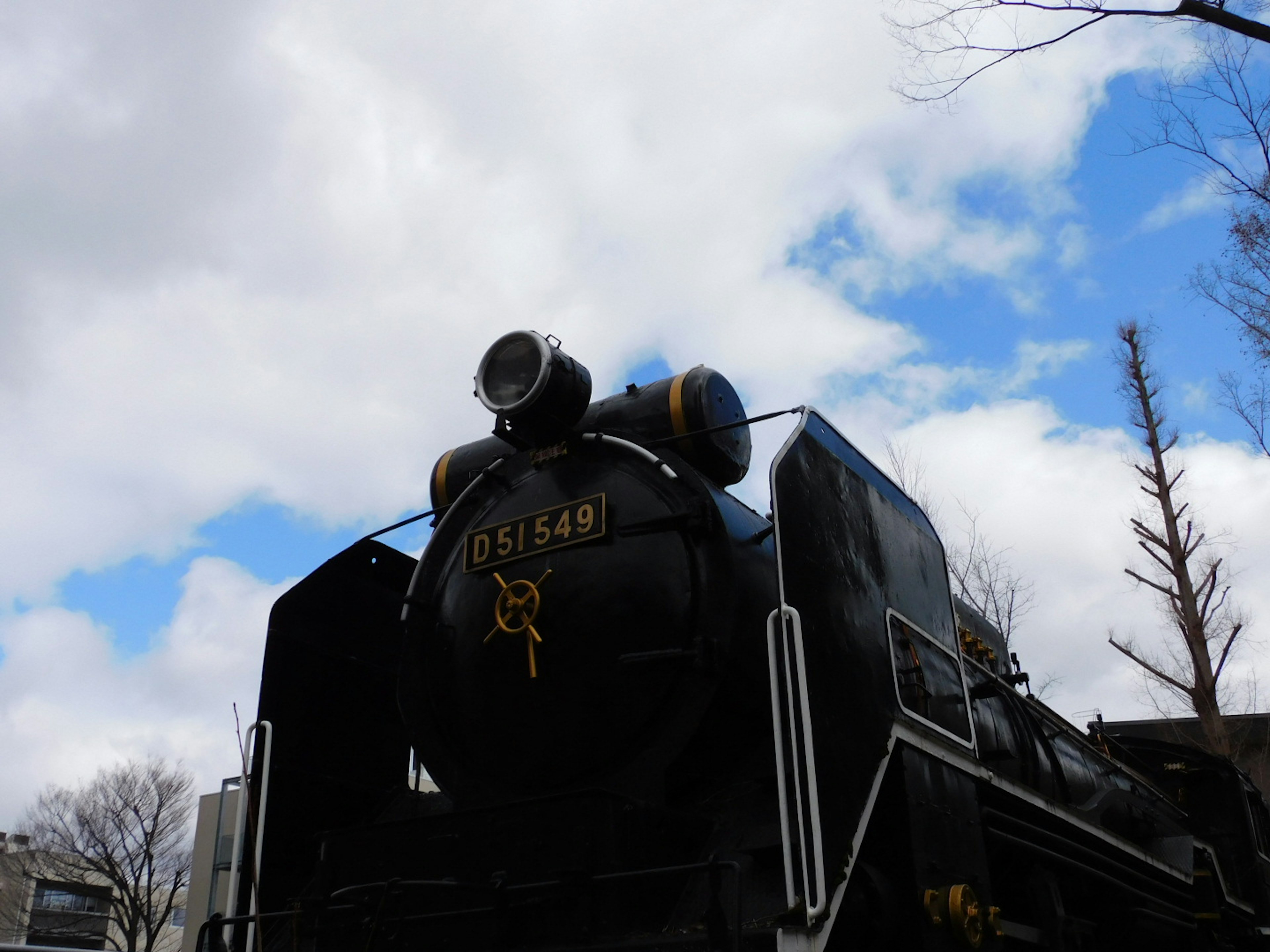 black steam locomotive with a blue sky backdrop