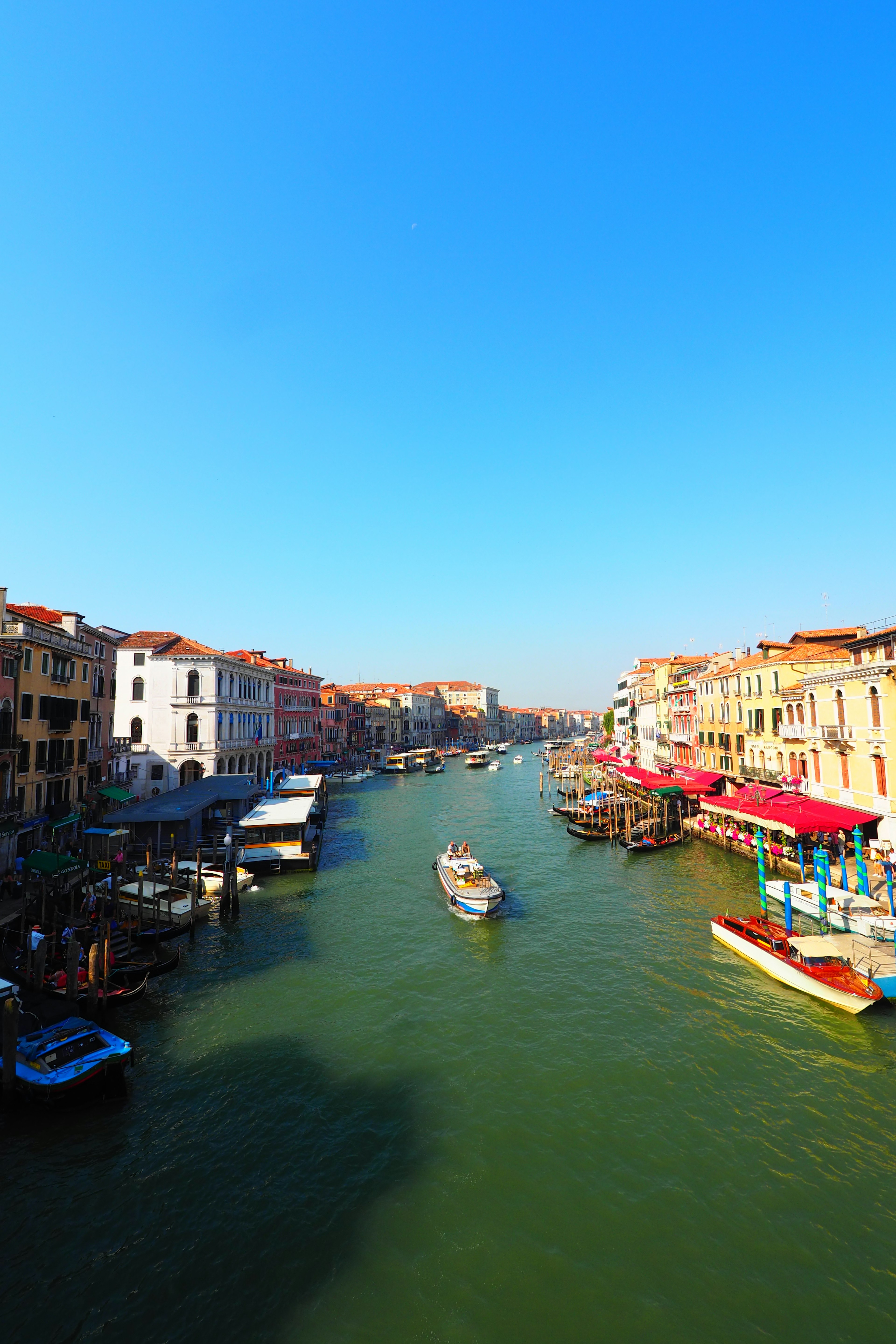 Venice canal with colorful buildings under a clear blue sky