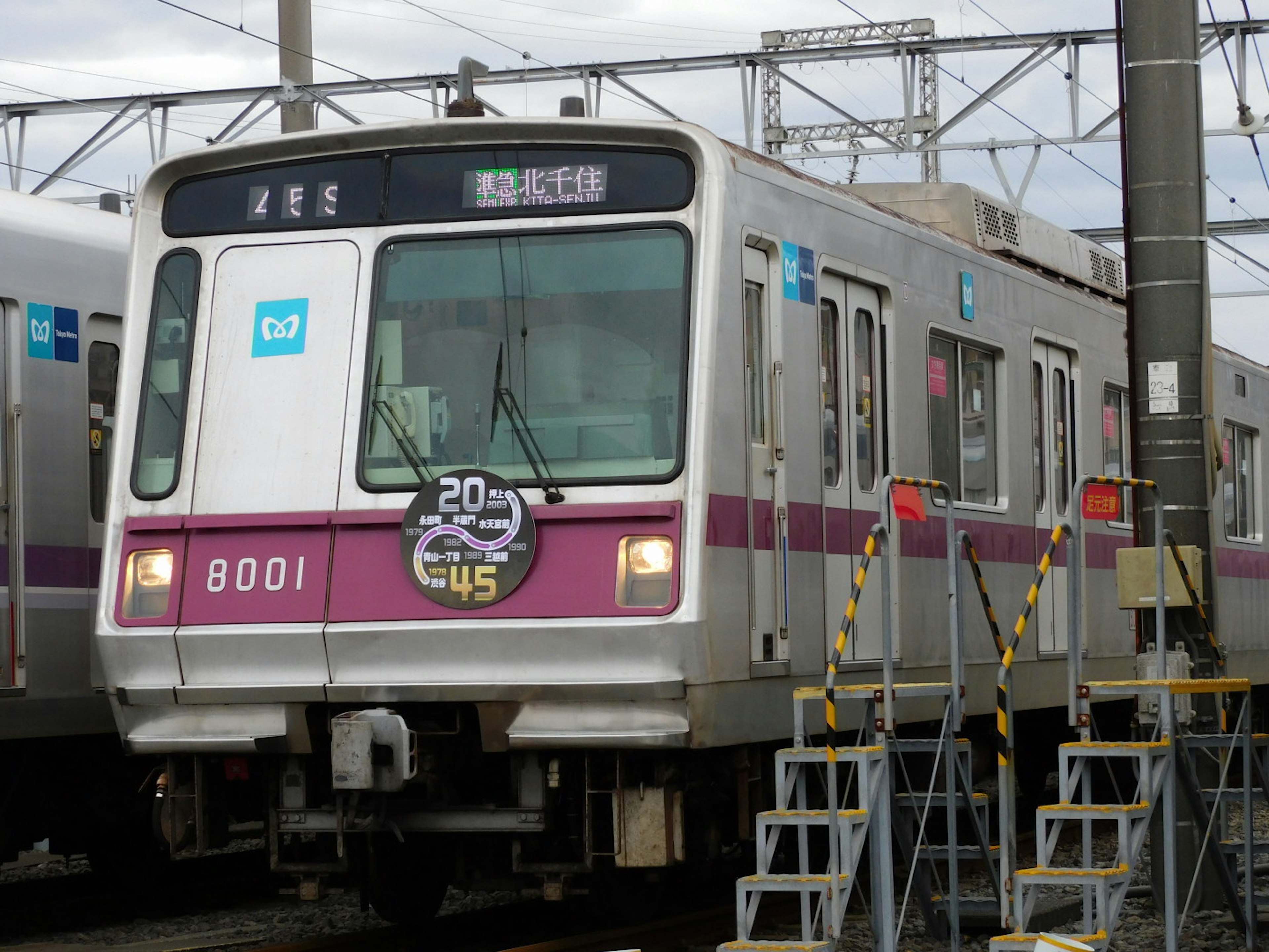 Tren con una franja morada llegando a la estación