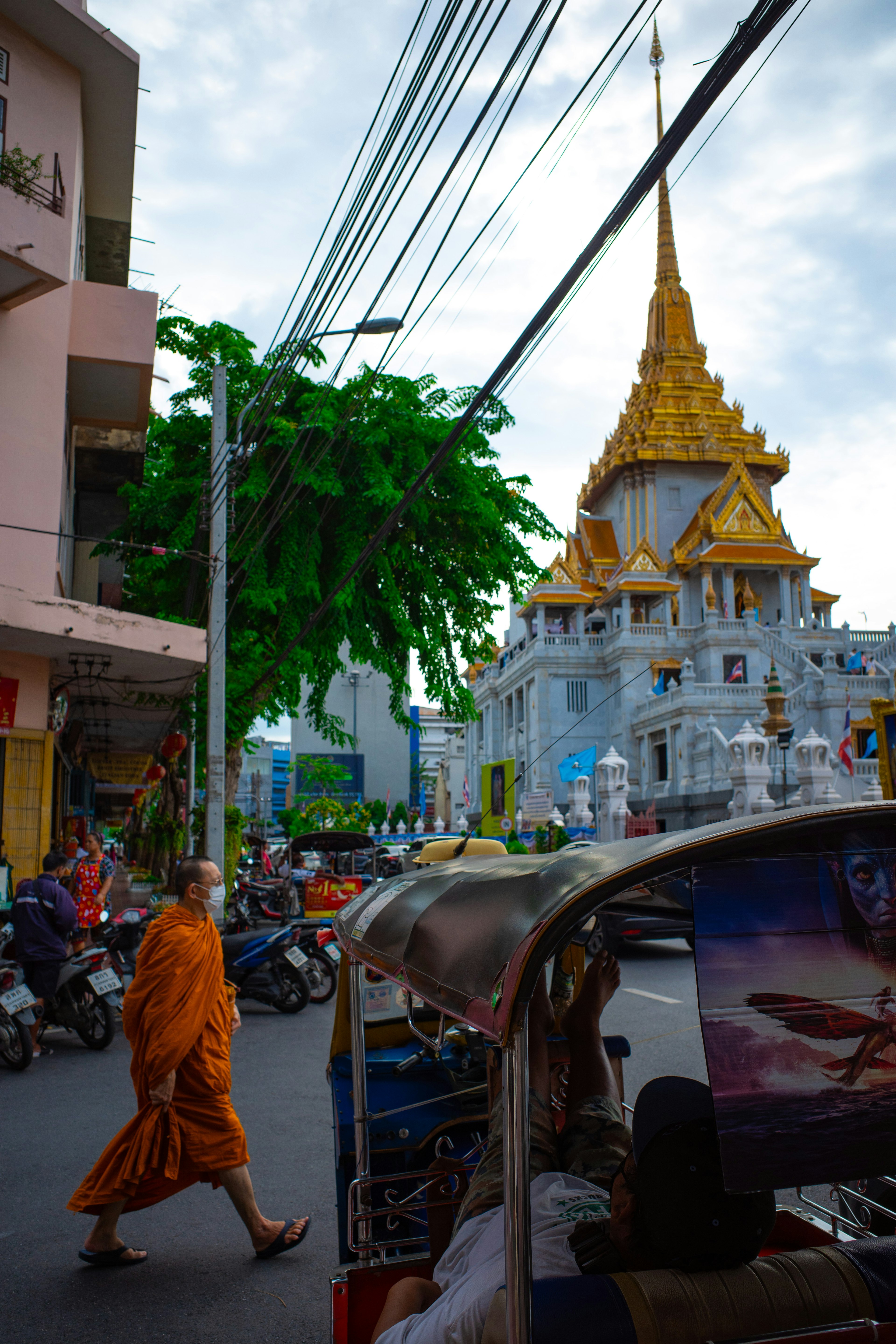 พระสงฆ์เดินอยู่กับวัดทองอยู่เบื้องหลังและทิวทัศน์เมือง