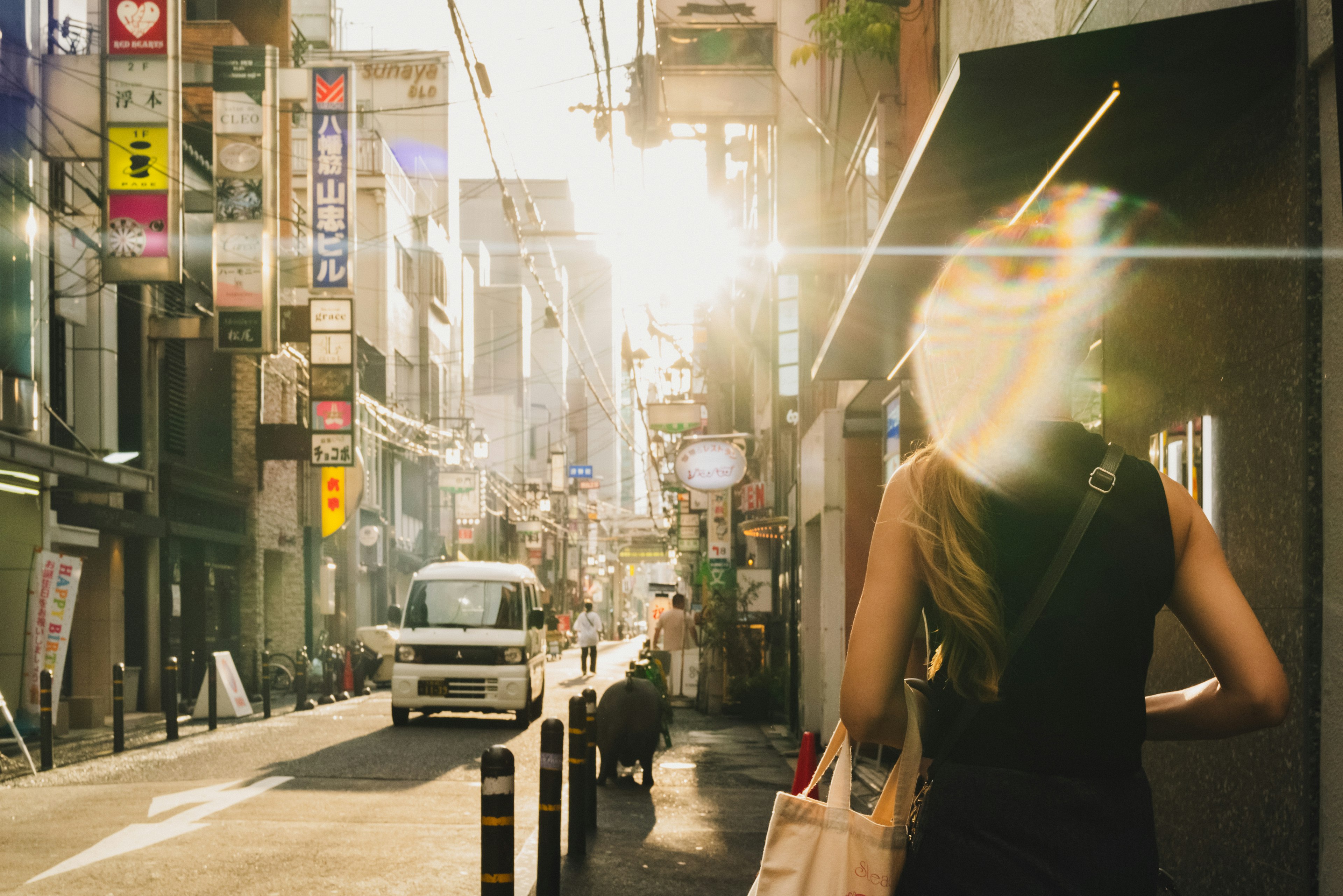 Femme marchant dans une rue de la ville avec la lumière du soleil