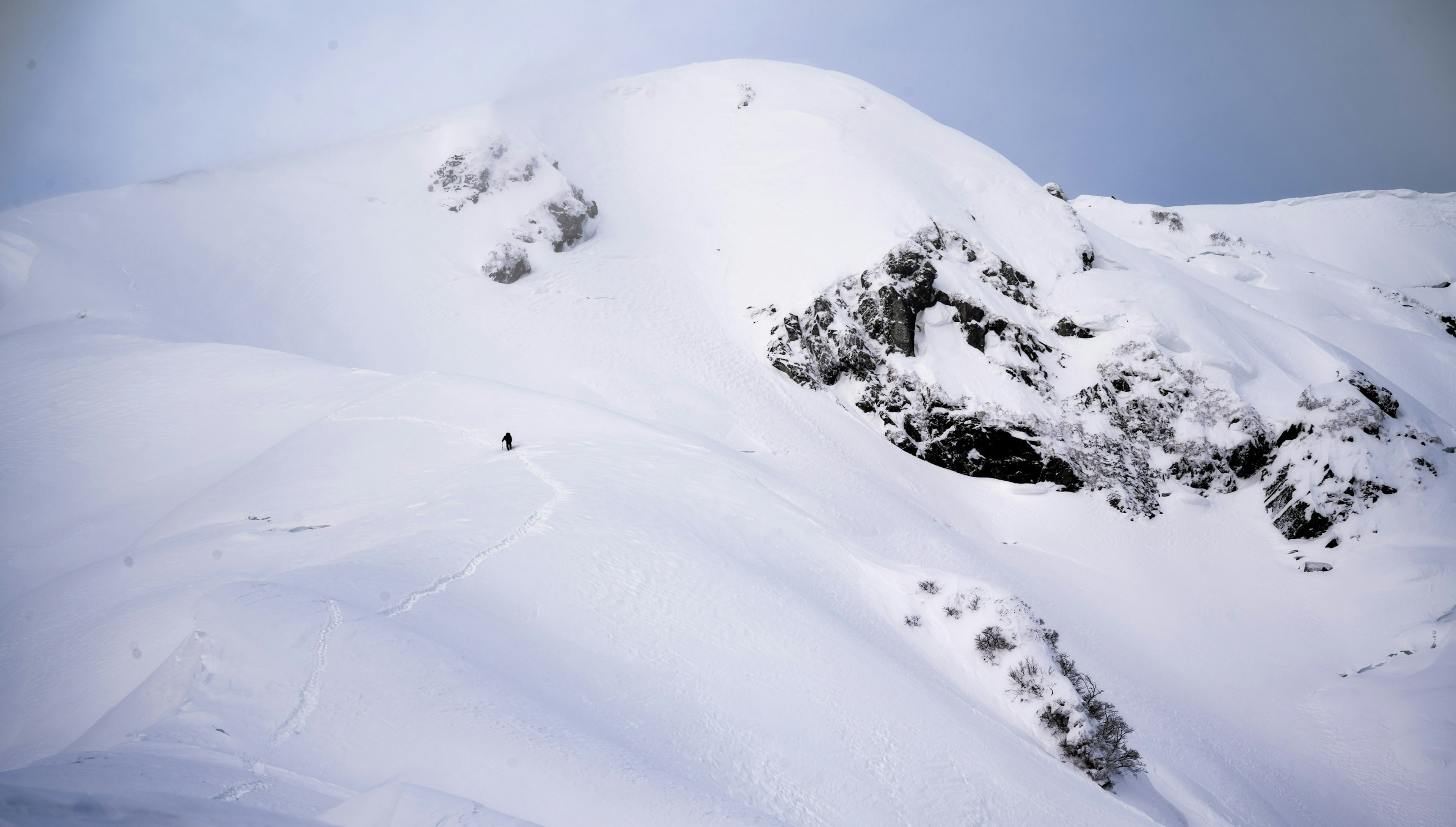 Snow-covered mountain landscape with exposed rocks