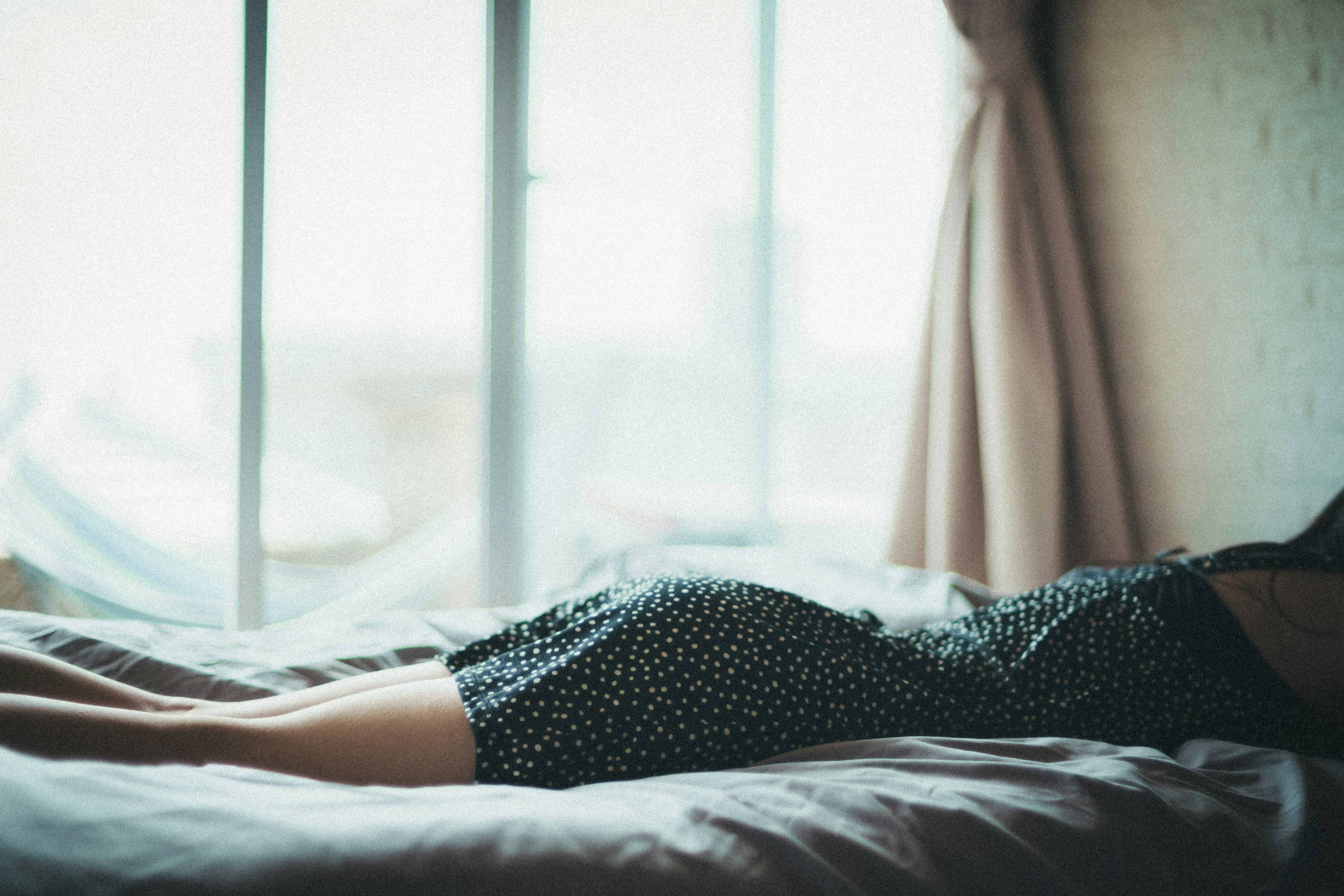 A scene featuring a woman's legs lying near a window