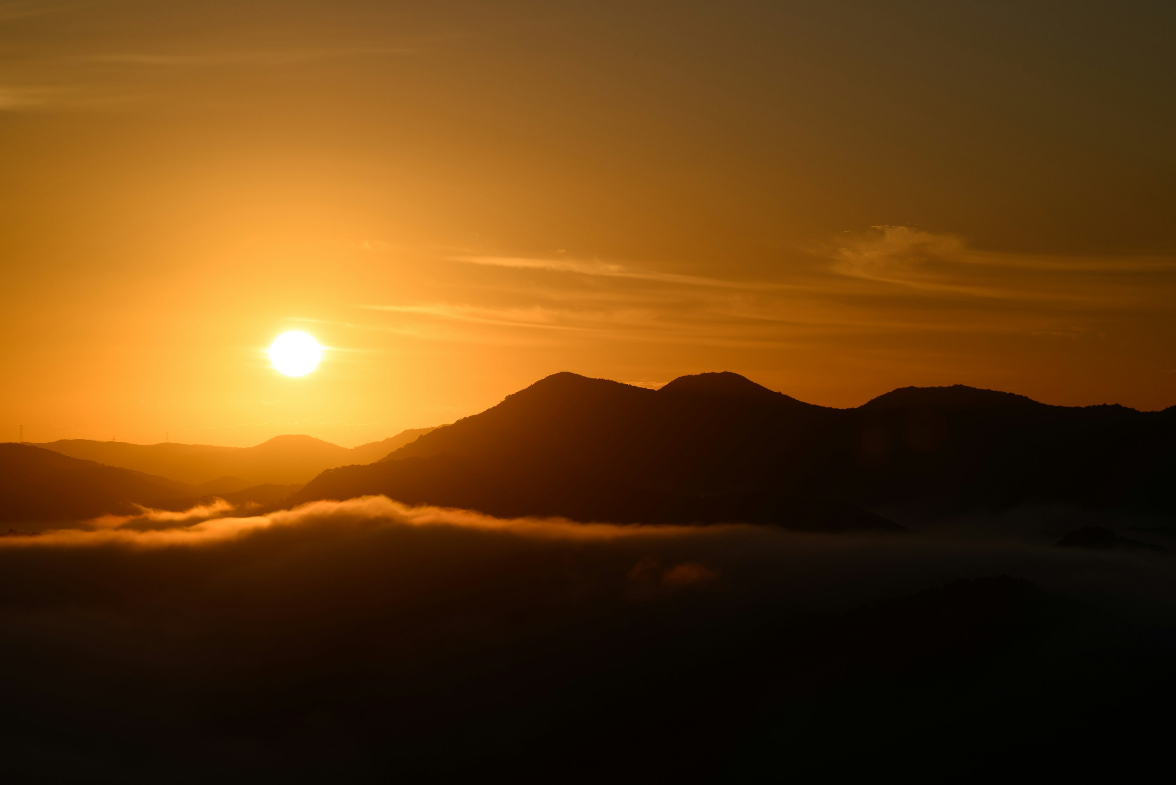 Hermoso paisaje con el sol poniéndose entre montañas