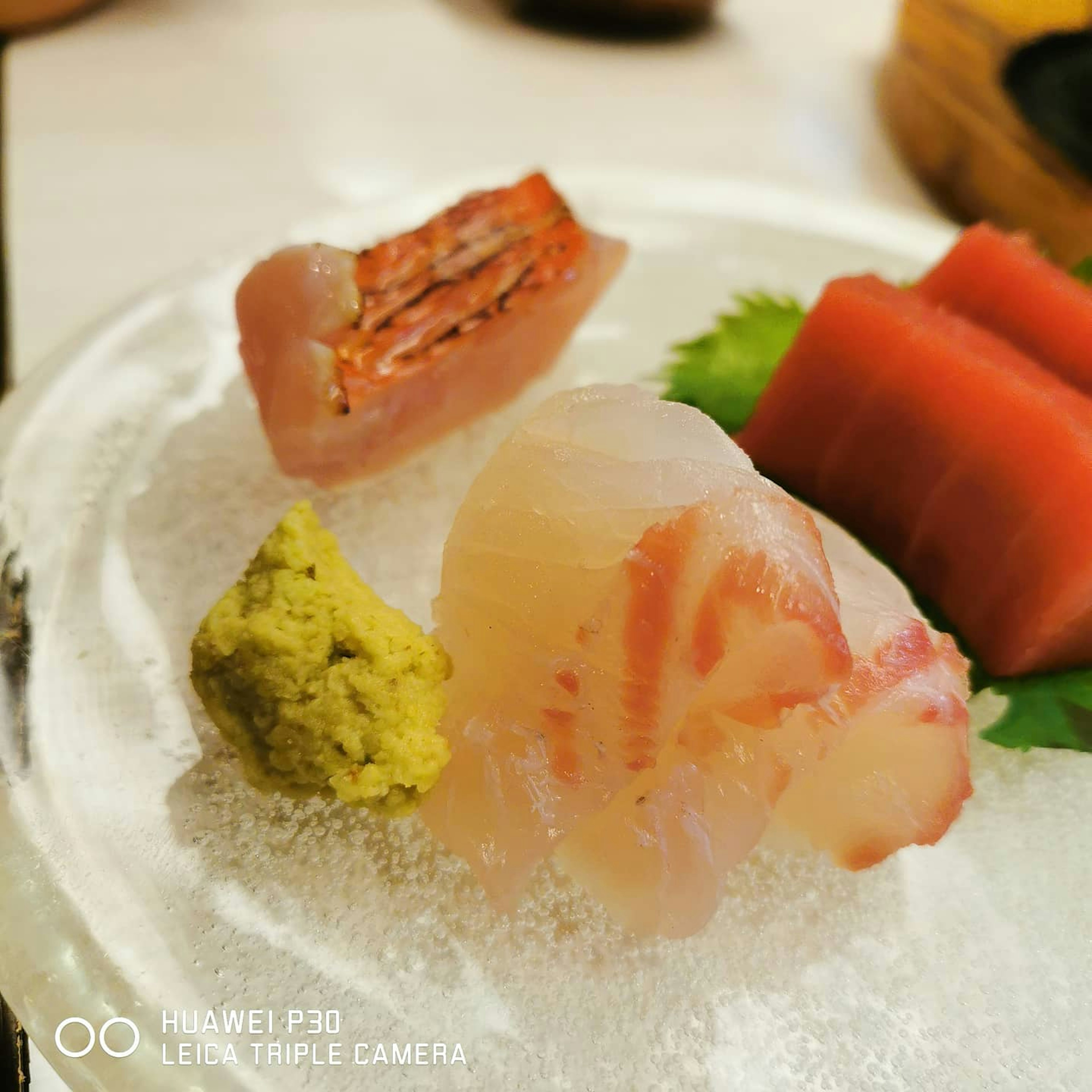 Fresh sashimi platter on ice featuring fish and wasabi