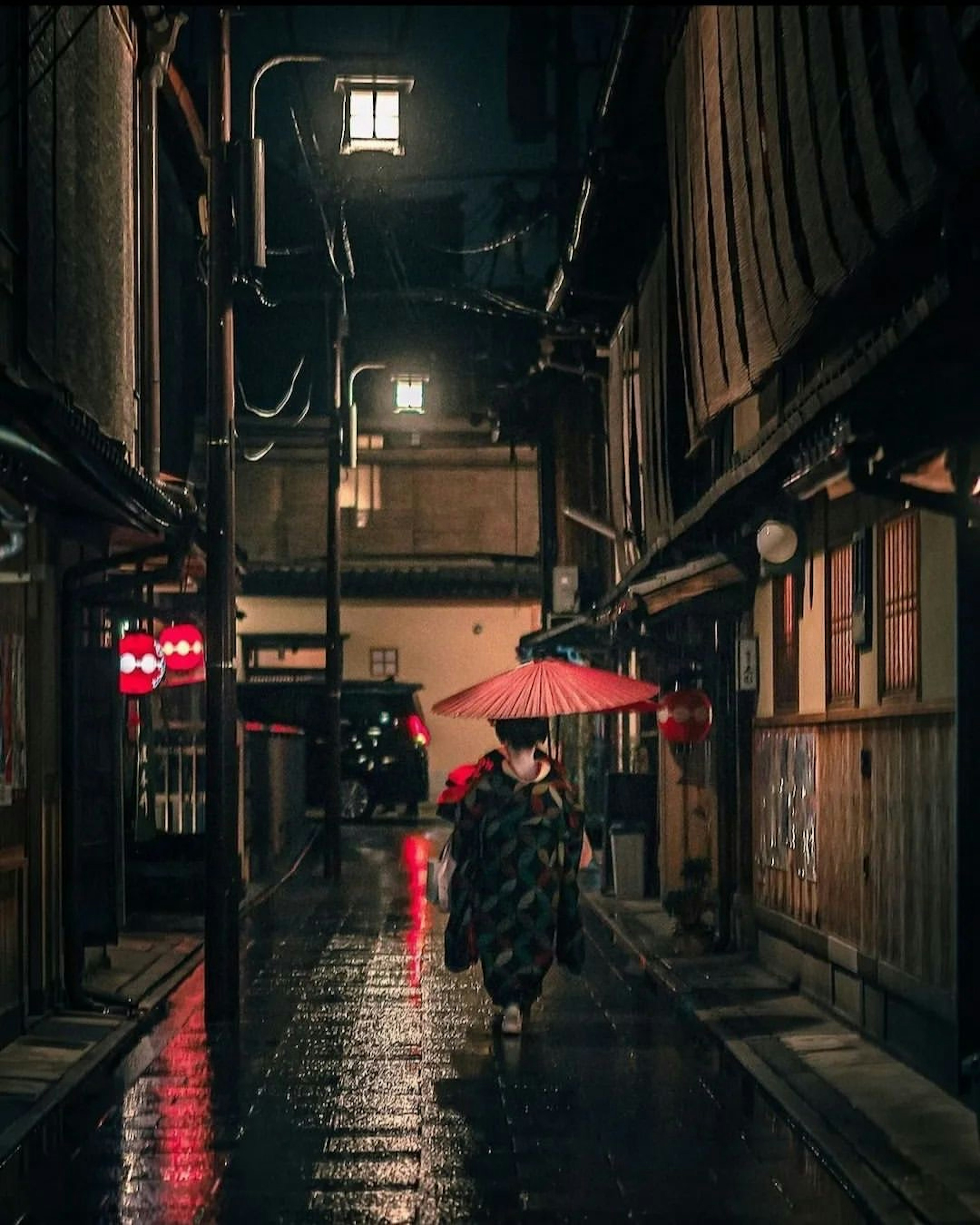 雨の中、傘を持って歩く着物を着た女性が狭い路地を進む情景