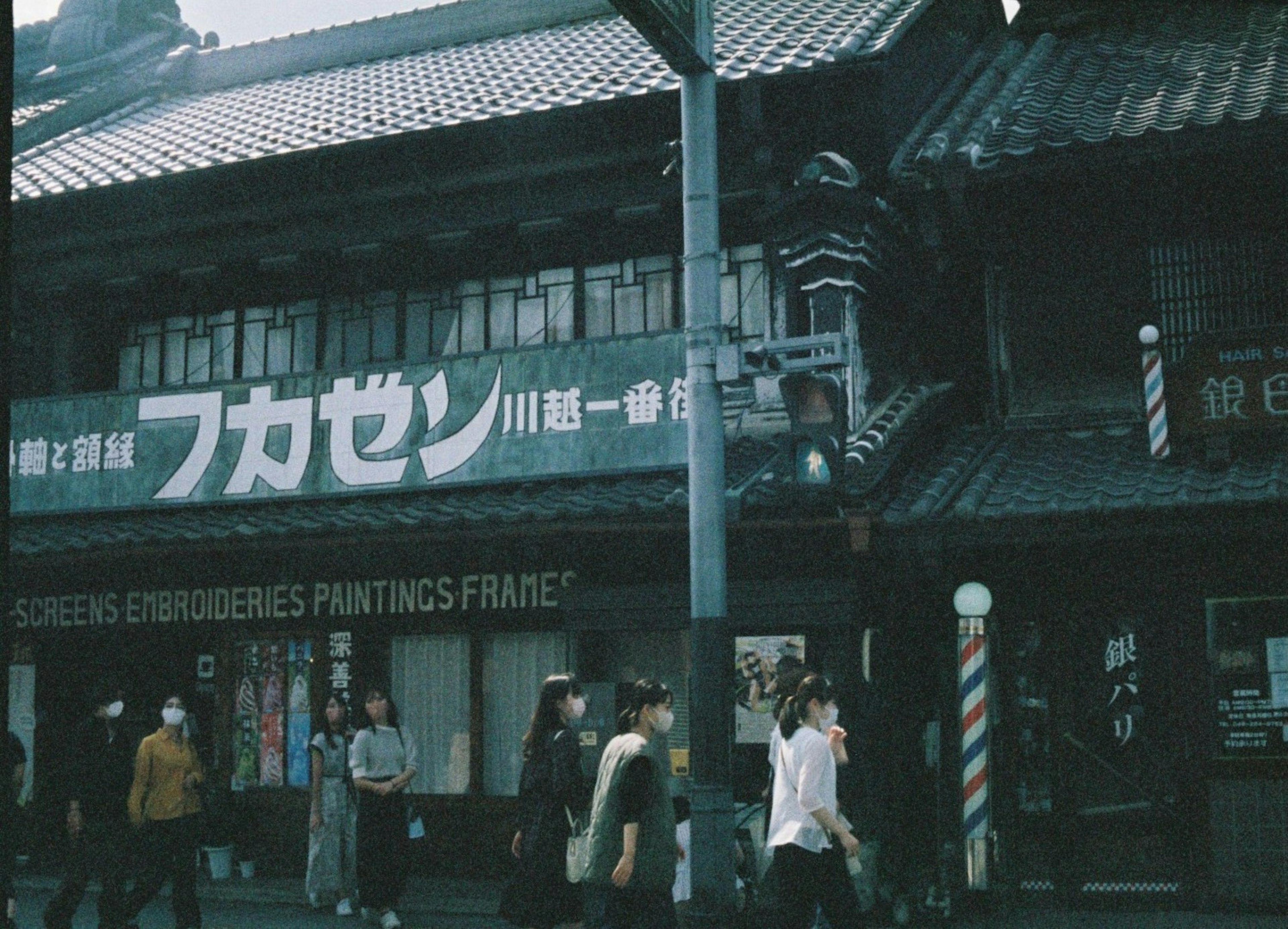 伝統的な建物の前を歩く人々と大きな看板