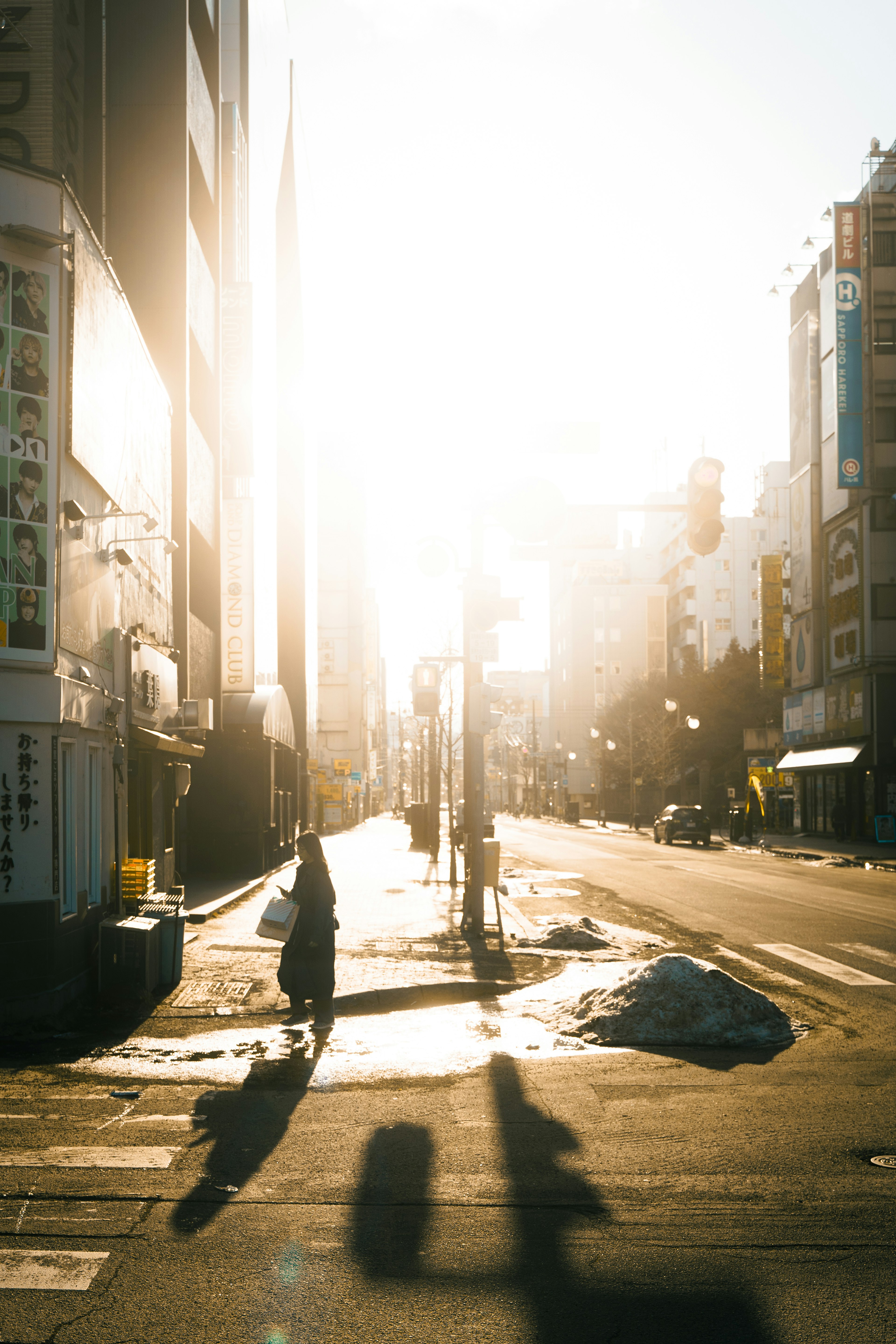 Eine Stadtstraße mit einer Silhouette einer Person, die im hellen Sonnenlicht geht