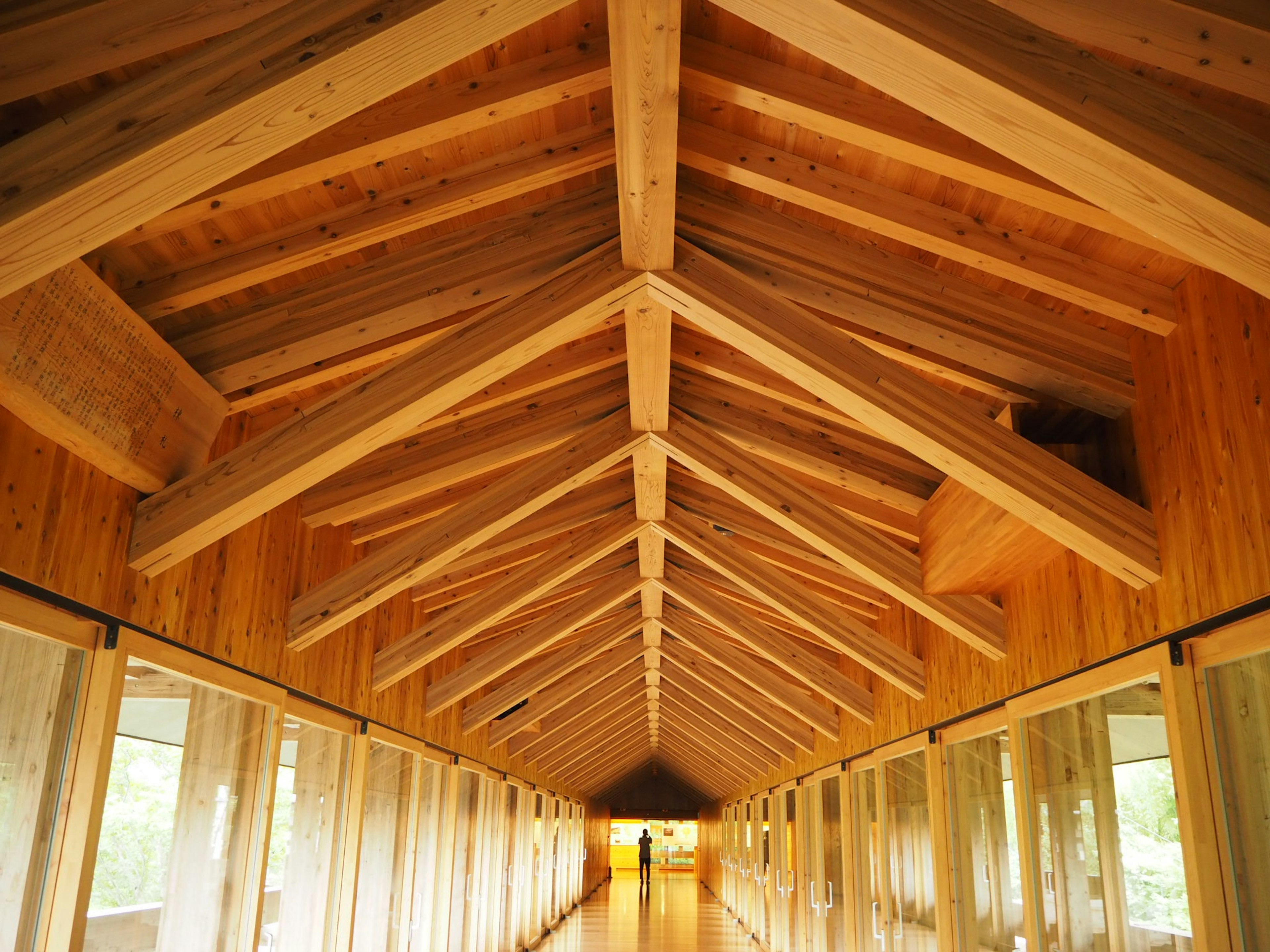 Interior de un largo pasillo con techo de madera