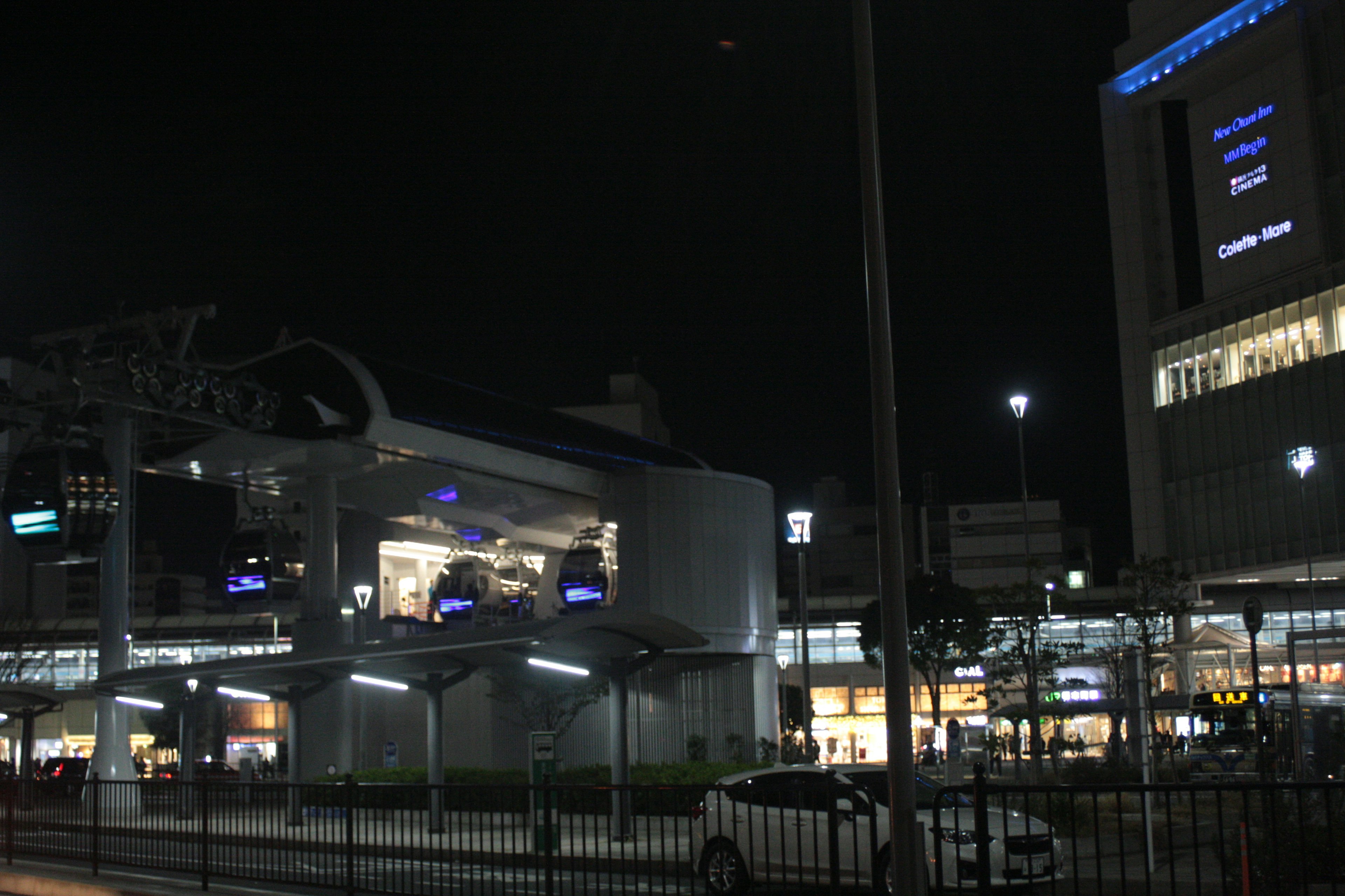 夜の駅の光景 駅の近代的な建物と看板が見える