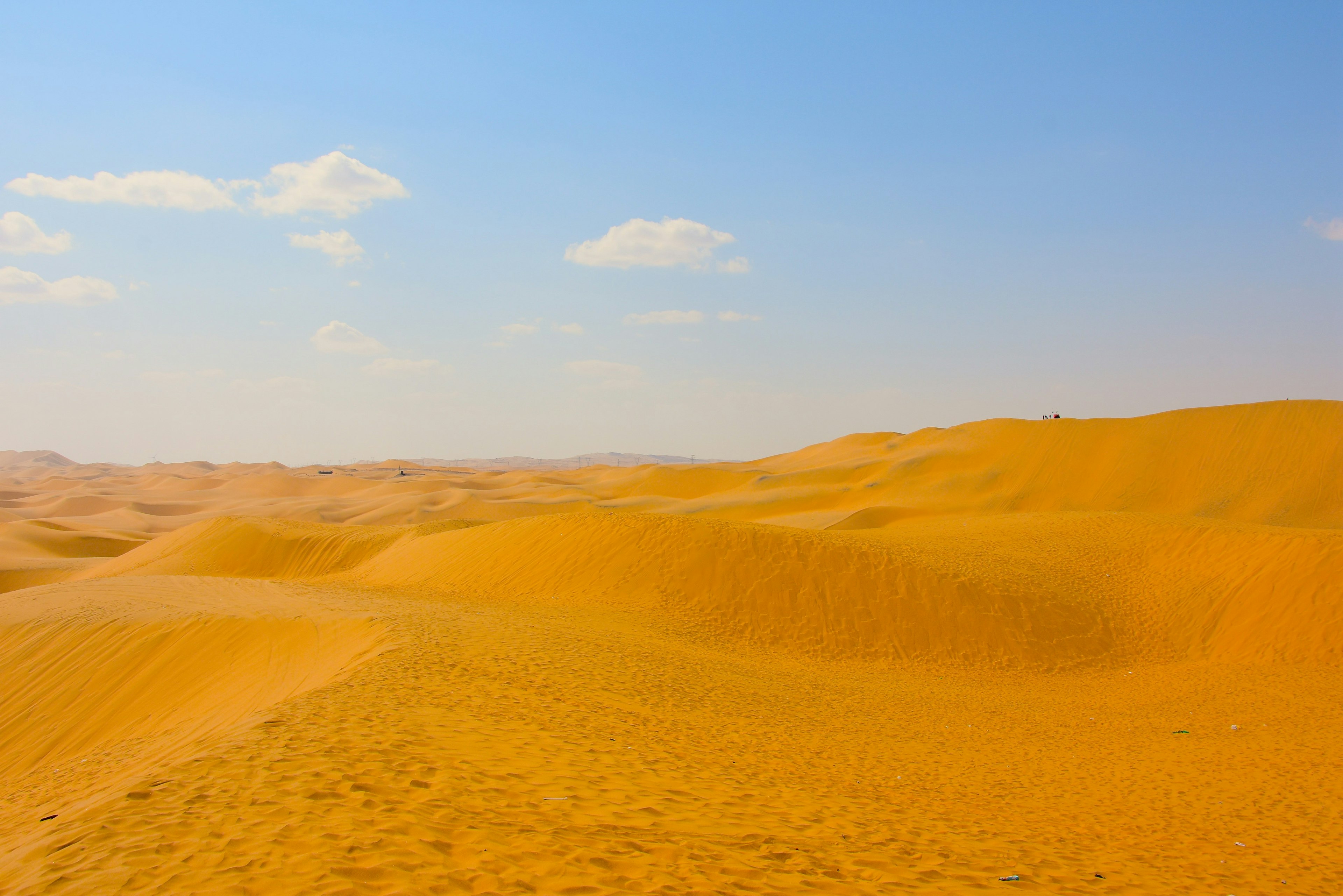 Vast sand dunes under a blue sky