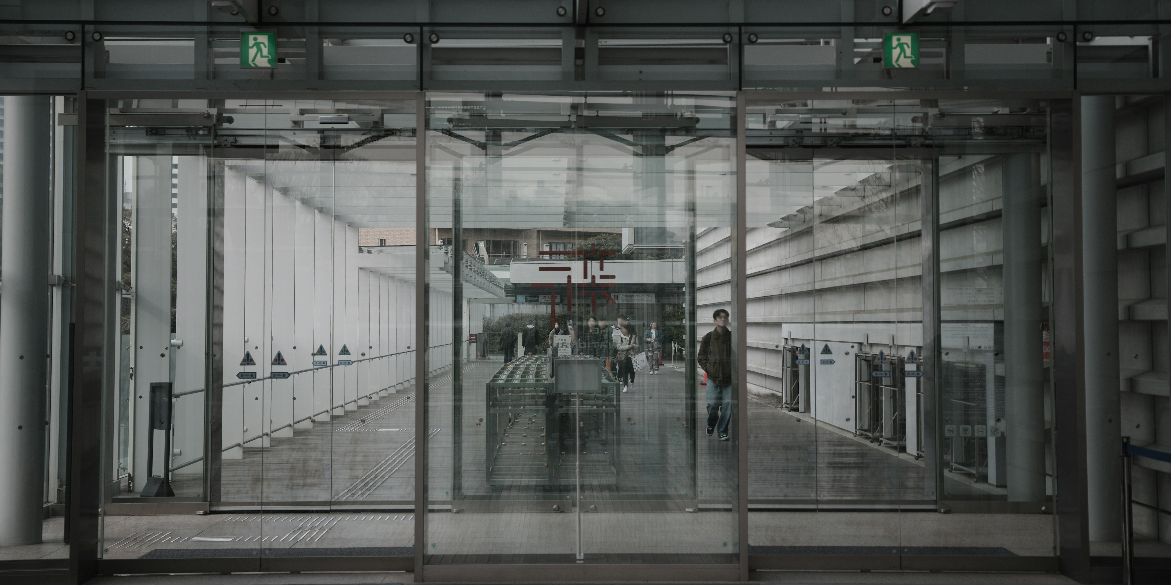 Intérieur d'un bâtiment moderne visible à travers des portes en verre avec des personnes