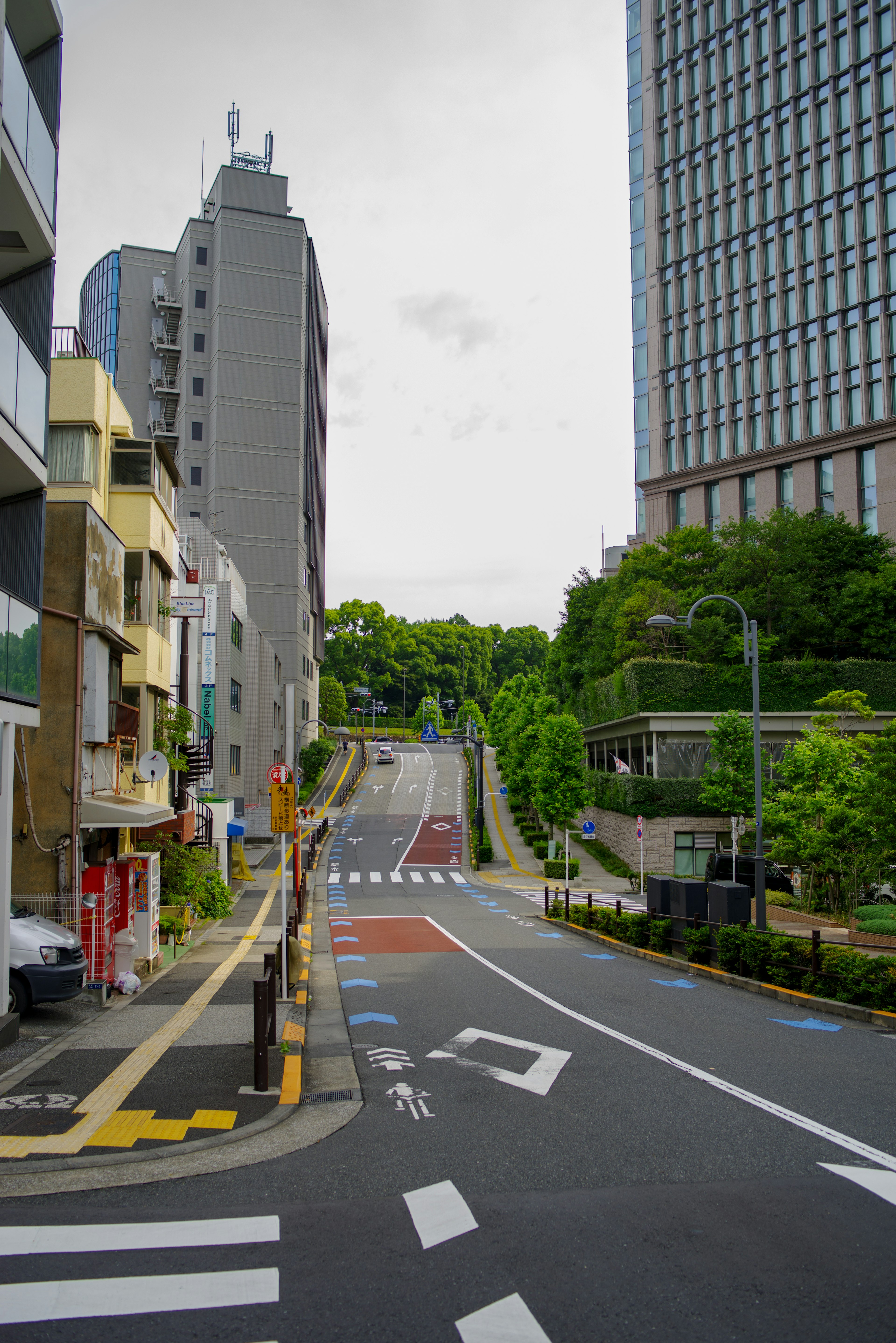 Urban street scene featuring buildings and green landscape