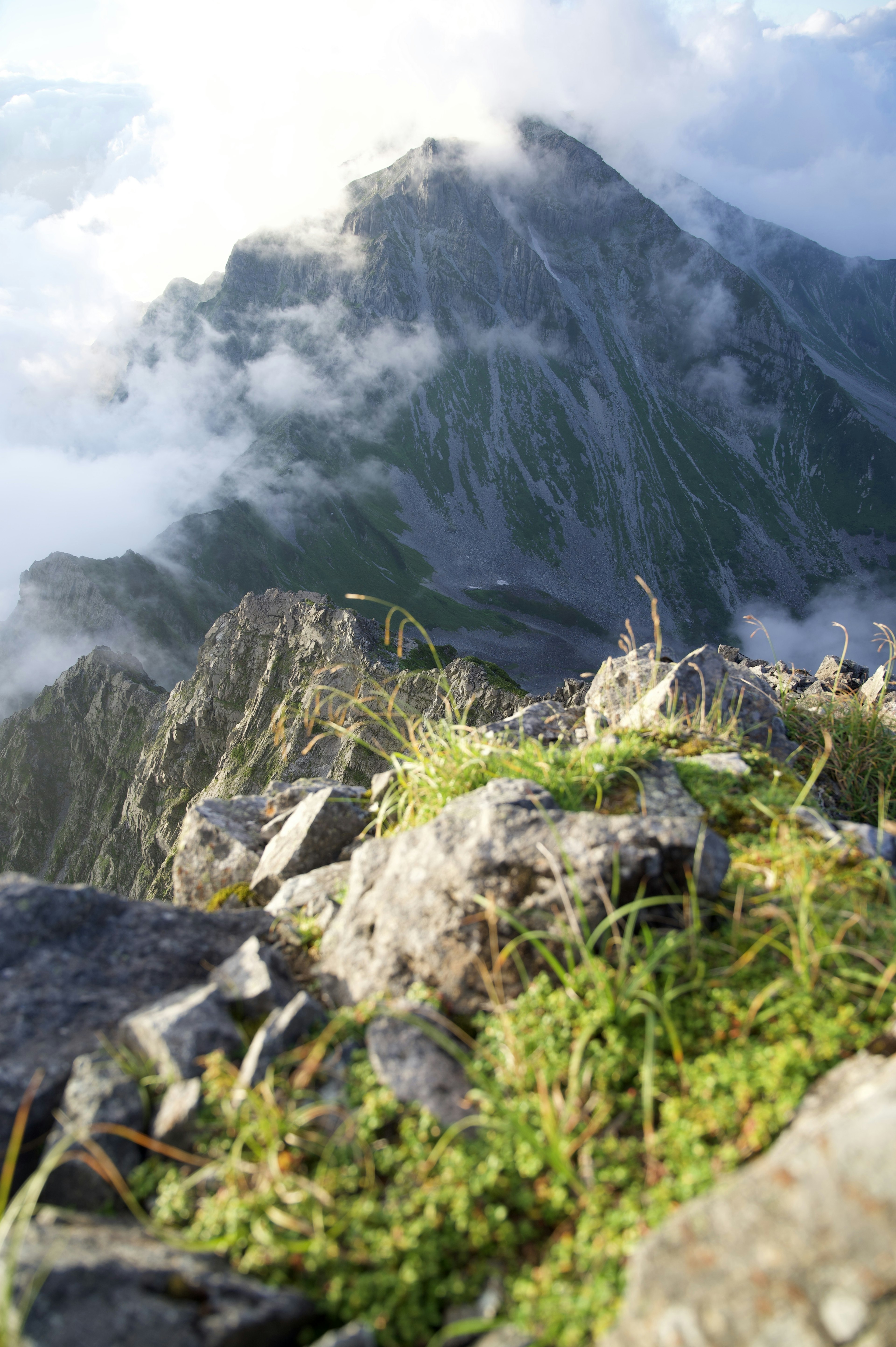 Pemandangan dari puncak gunung dengan awan di sekeliling