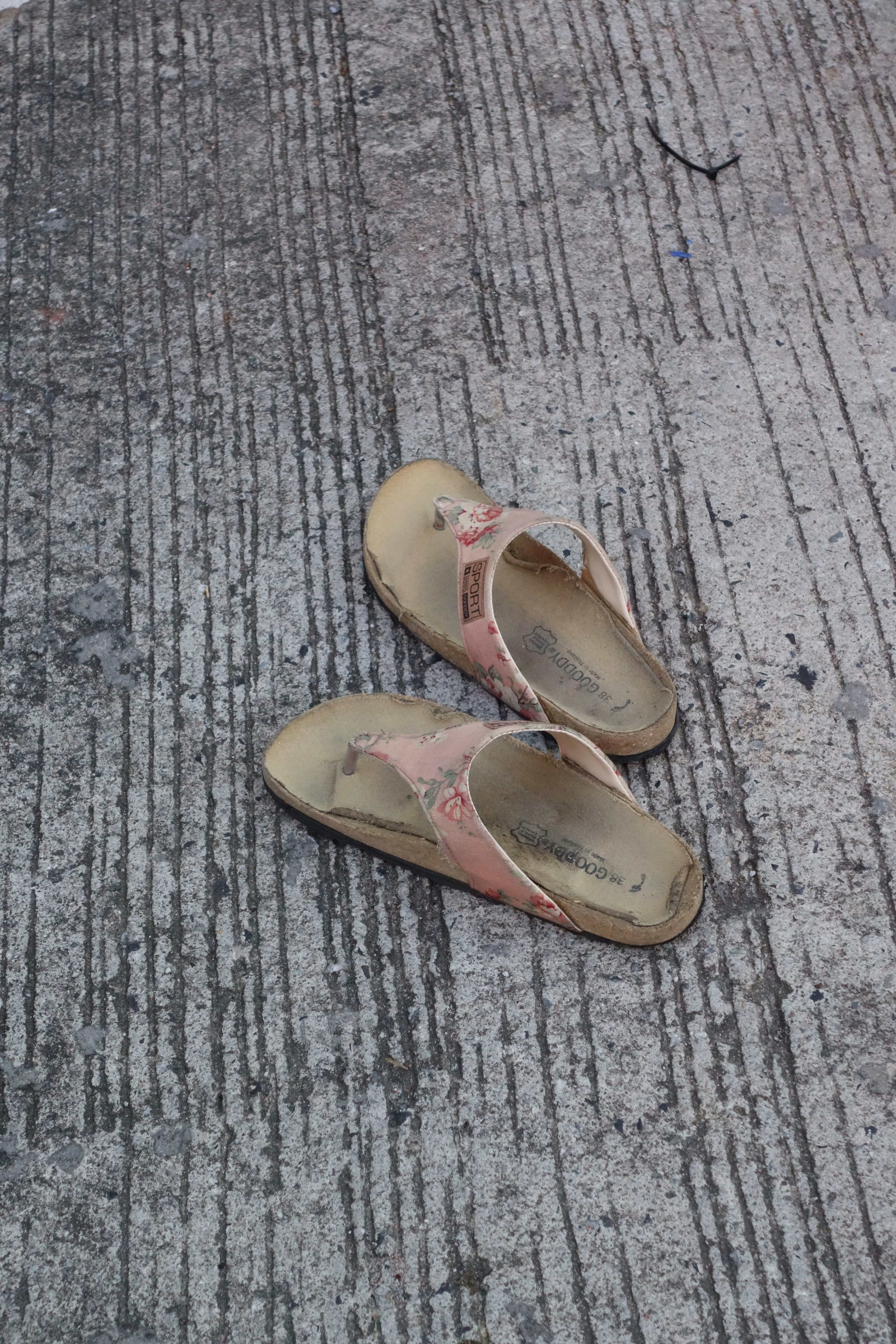 Pink sandals placed on a concrete surface