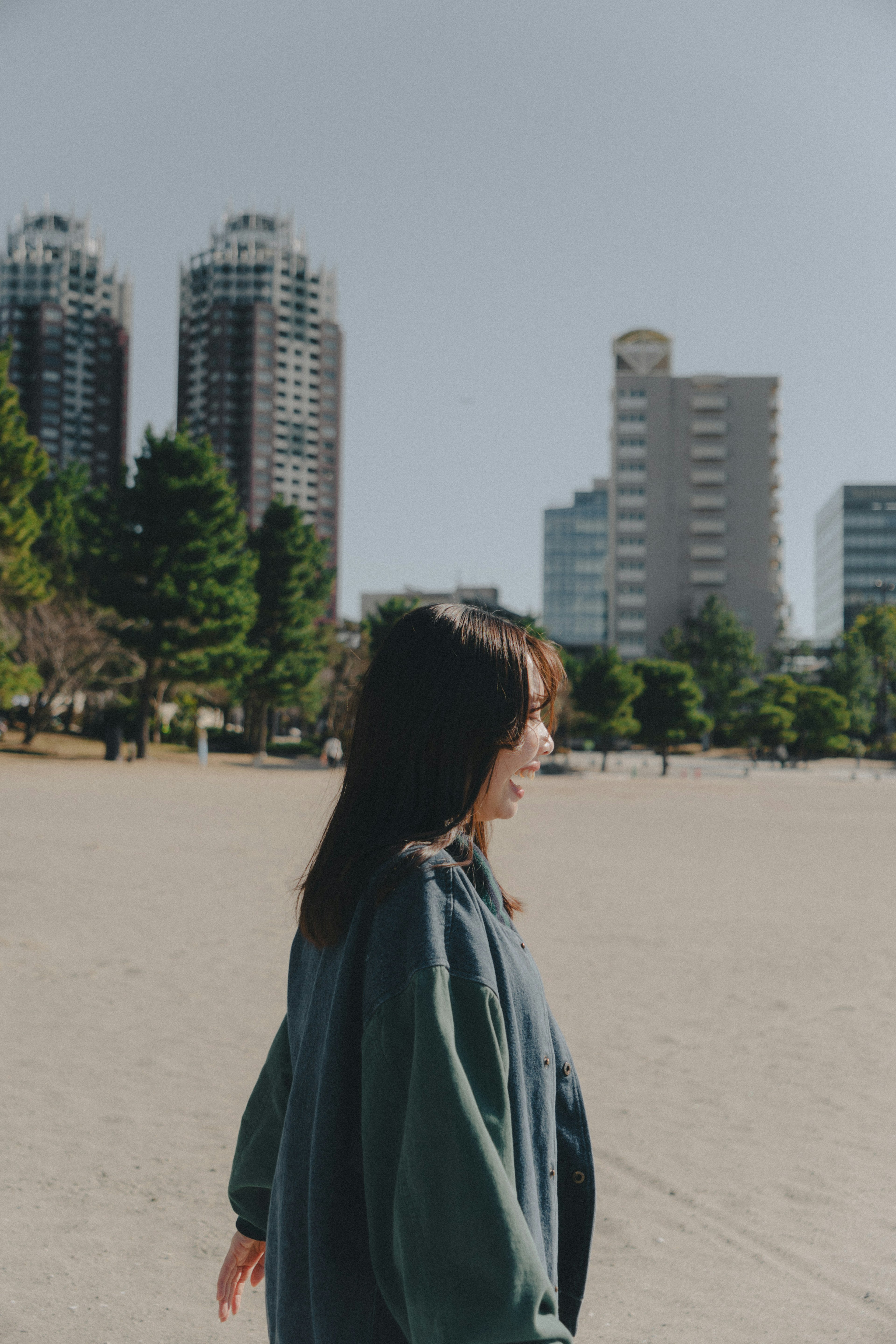 女性がビーチで歩いている風景 高層ビルが背景にある