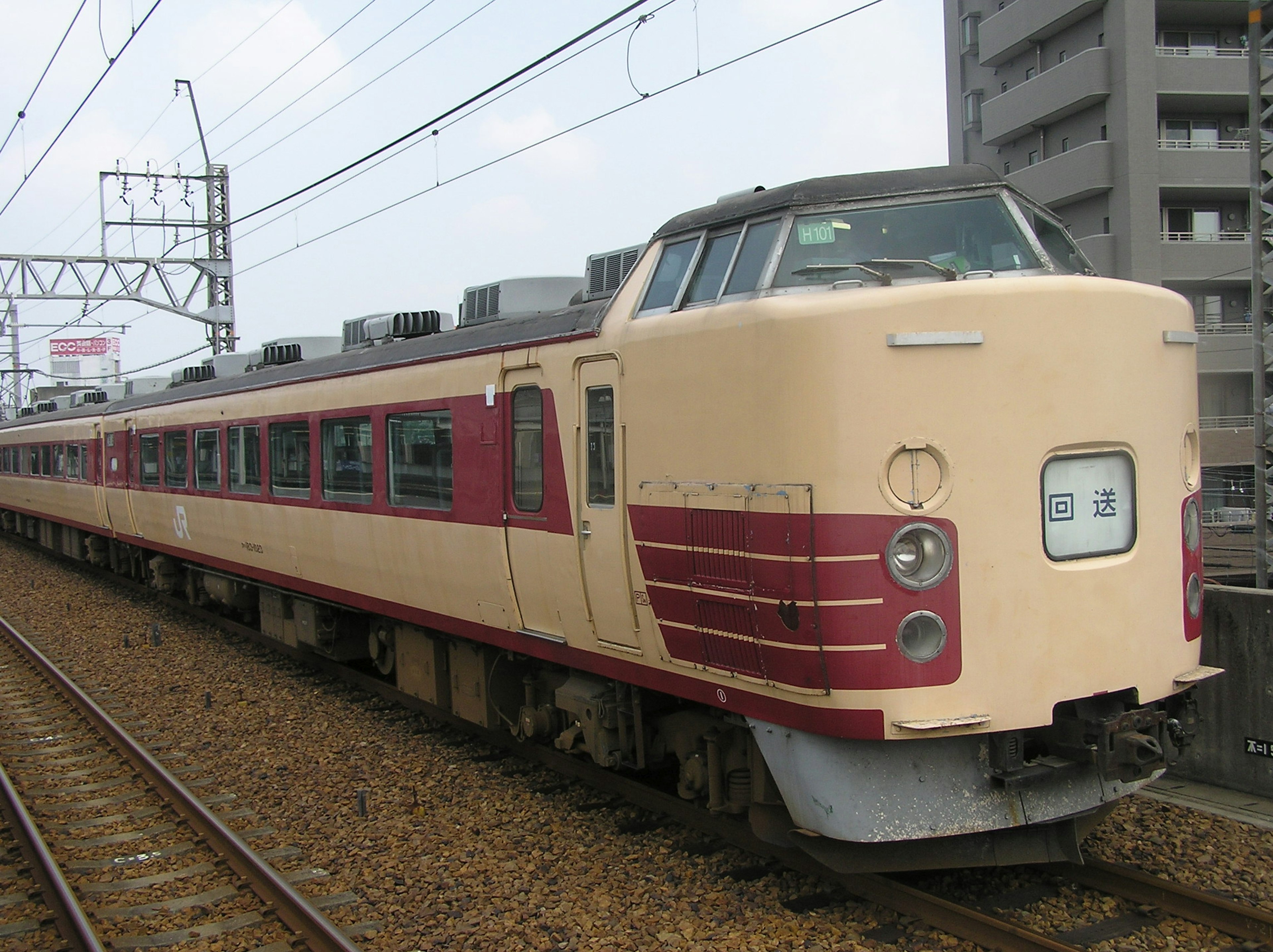 Tren con un diseño rojo y crema estacionado en las vías