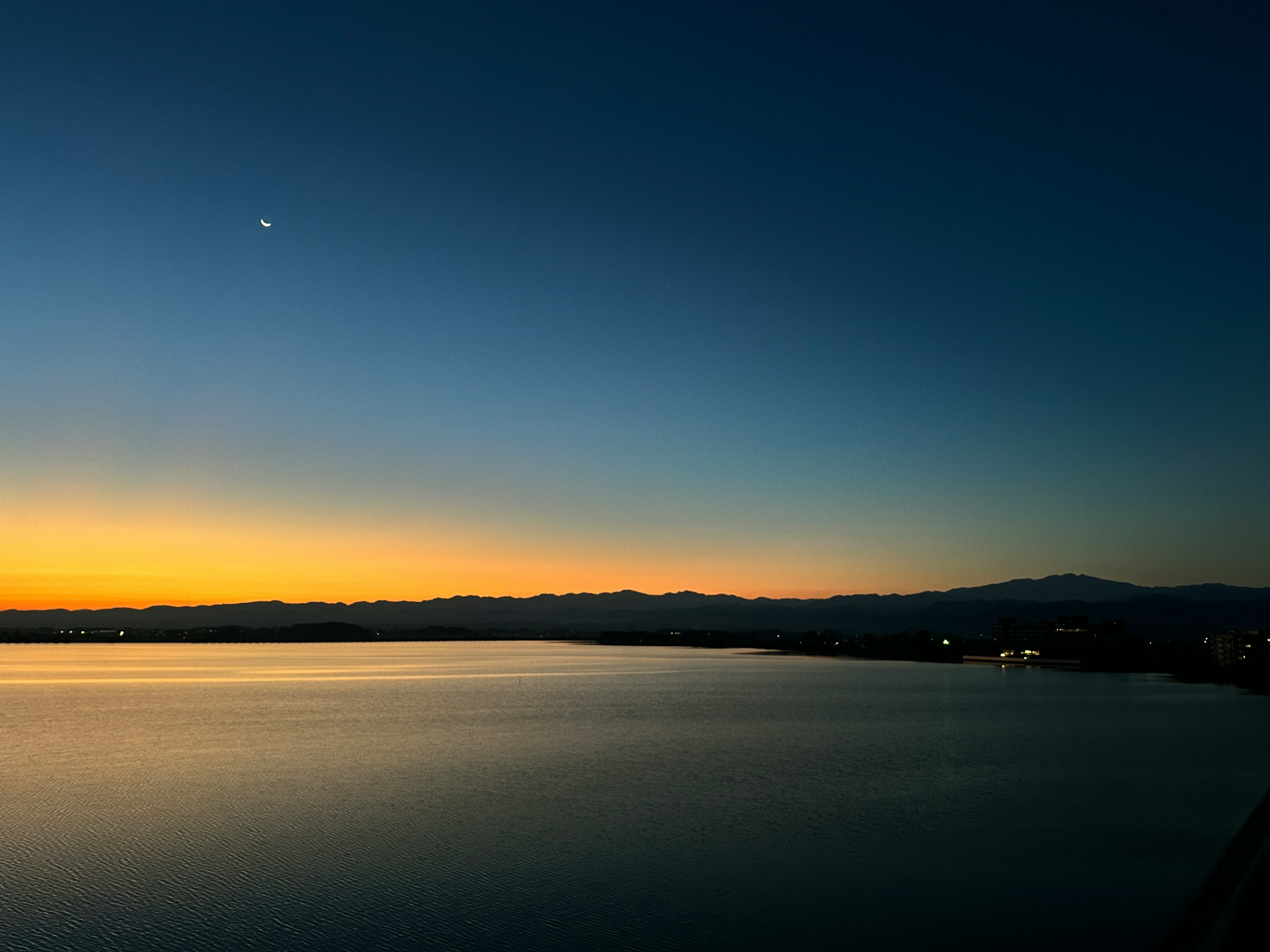 Beautiful lake view at sunset with silhouetted mountains
